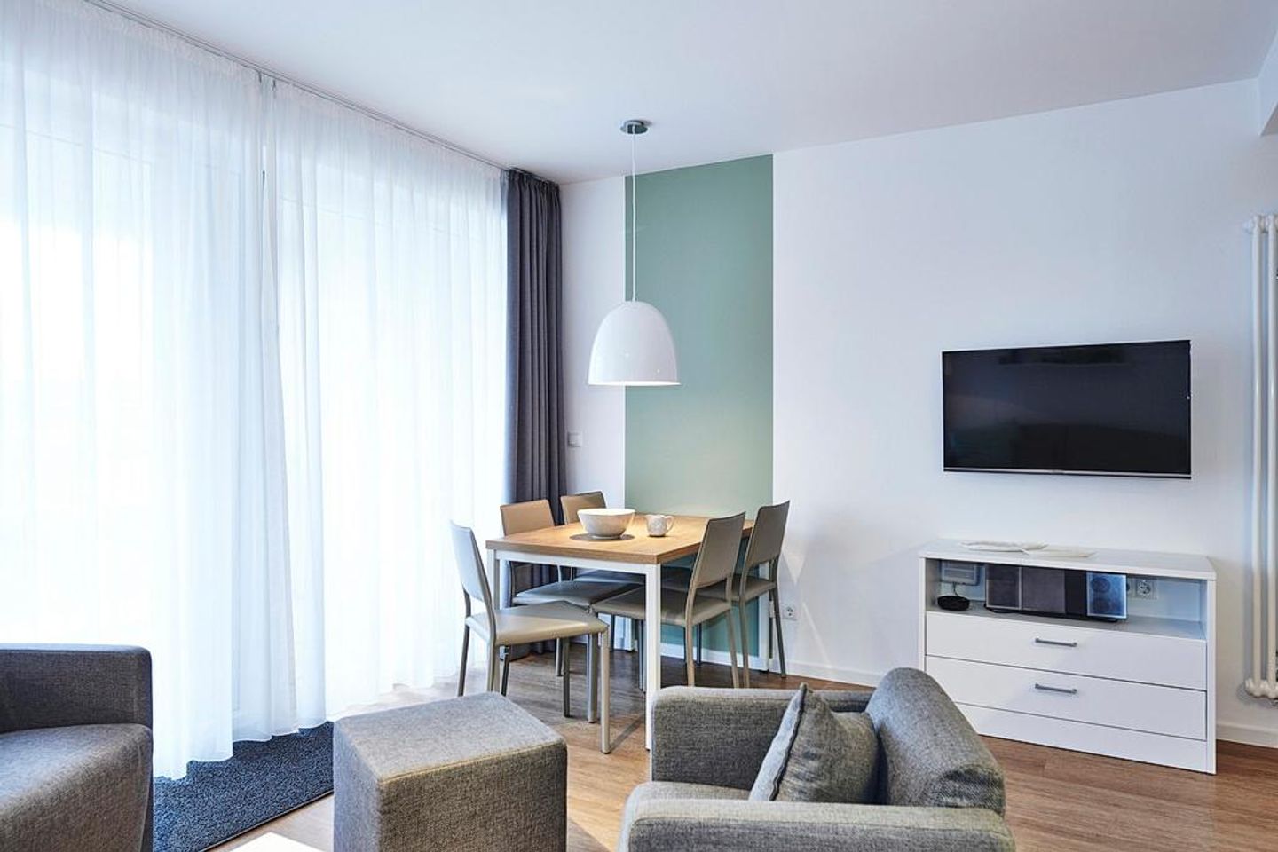 Deichhäuser Anna Küste Deichhäuser Anna Küste 4-23 Bensersiel - Wohn-Essbereich mit Esstisch, Sitzgelegenheit und Flatscreen TV