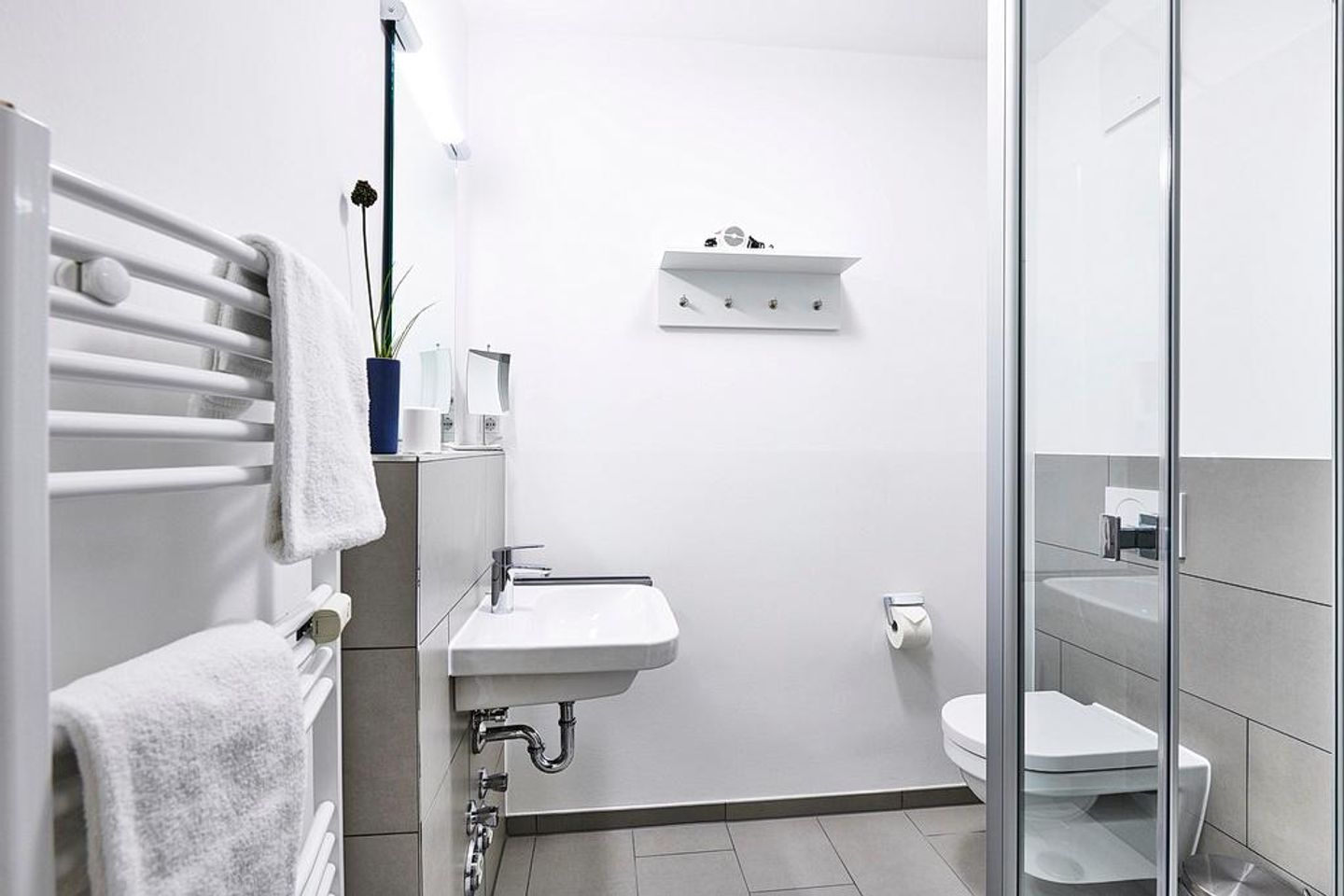 Deichhäuser Anna Küste Deichhäuser Anna Küste 4-23 Bensersiel - Badezimmer mit Dusche, Waschtisch, WC und Spiegel