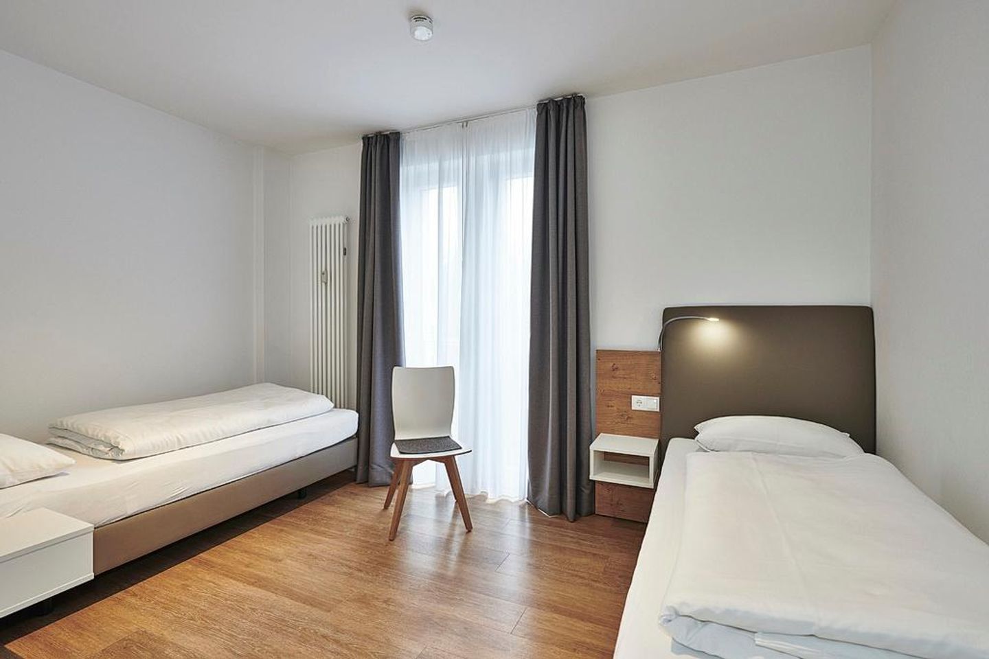 Deichhäuser Anna Küste Deichhäuser Anna Küste 4-24 Bensersiel - Schlafzimmer mit zwei Einzelbetten und Sitzgelegenheit