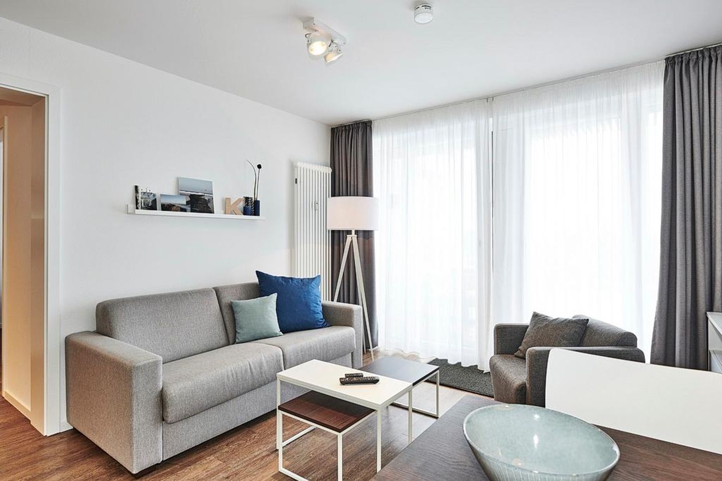 Deichhäuser Anna Küste Deichhäuser Anna Küste 4-31 Bensersiel - Wohnbereich mit Couch und Zugang zum Balkon