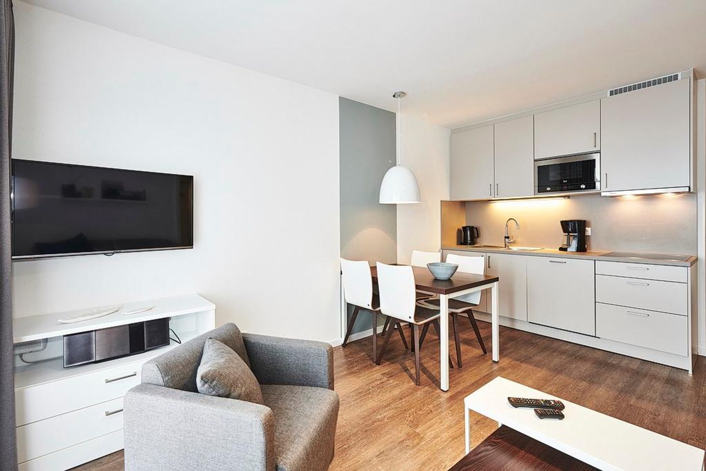 Deichhäuser Anna Küste Deichhäuser Anna Küste 4-31 Bensersiel - Wohnbereich mit Küchenzeile, Esstisch, Sitzgelegenheit und Flatscreen TV