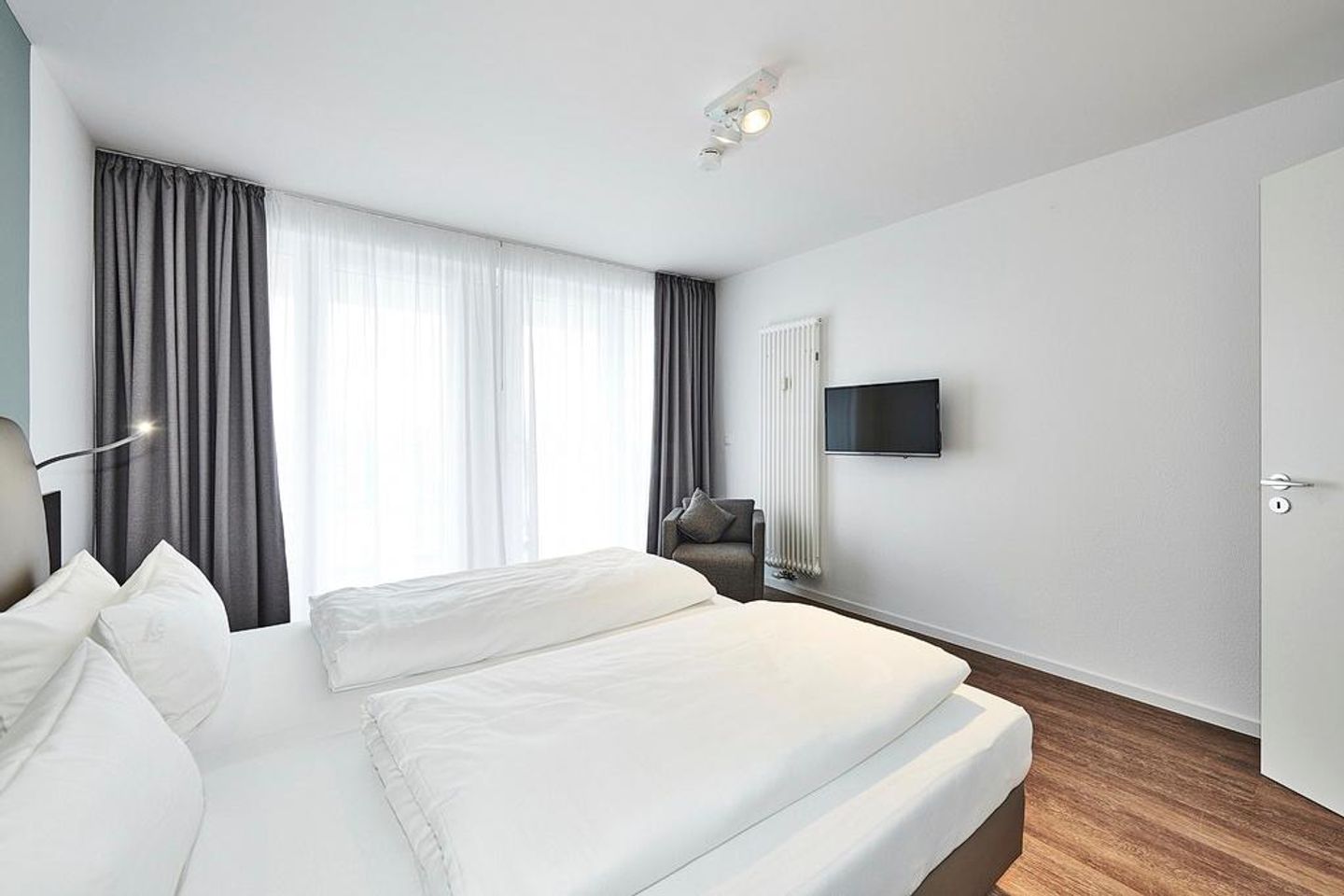 Deichhäuser Anna Küste Deichhäuser Anna Küste 4-31 Bensersiel - Schlafzimmer mit Doppelbett, Flatscreen-TV und Zugang zum Balkon