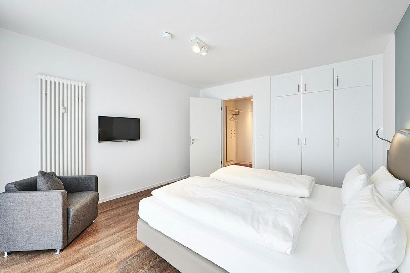 Deichhäuser Anna Küste Deichhäuser Anna Küste 4-31 Bensersiel - Schlafzimmer mit Doppelbett, Kleiderschrank, Sessel und Flatscreen TV