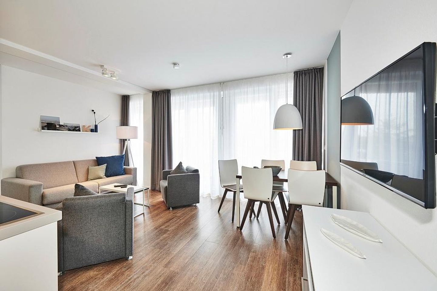 Deichhäuser Anna Küste Deichhäuser Anna Küste 4-33 Bensersiel - Wohn-Essbereich mit Couch und Zugang zum Balkon