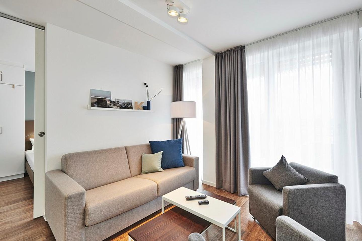 Deichhäuser Anna Küste Deichhäuser Anna Küste 4-33 Bensersiel - Wohnbereich mit Sofa, Sessel, Couchtisch und Zugang zum Balkon