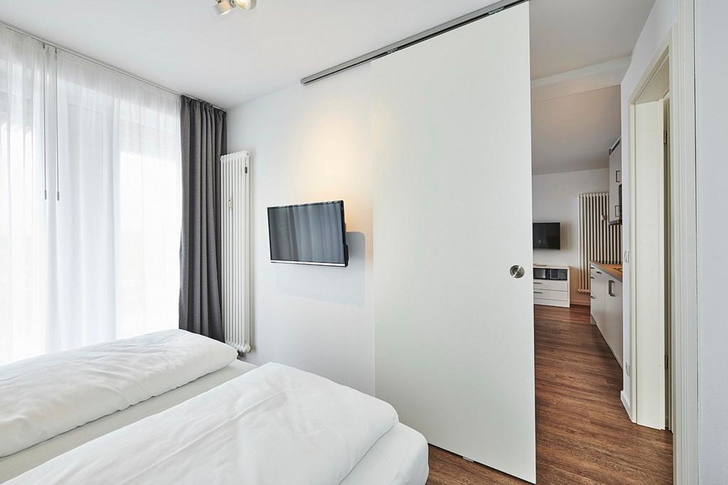 Deichhäuser Anna Küste Deichhäuser Anna Küste 4-33 Bensersiel - Schlafzimmer mit Doppelbett, Flatscreen-TV und Zugang zum Balkon