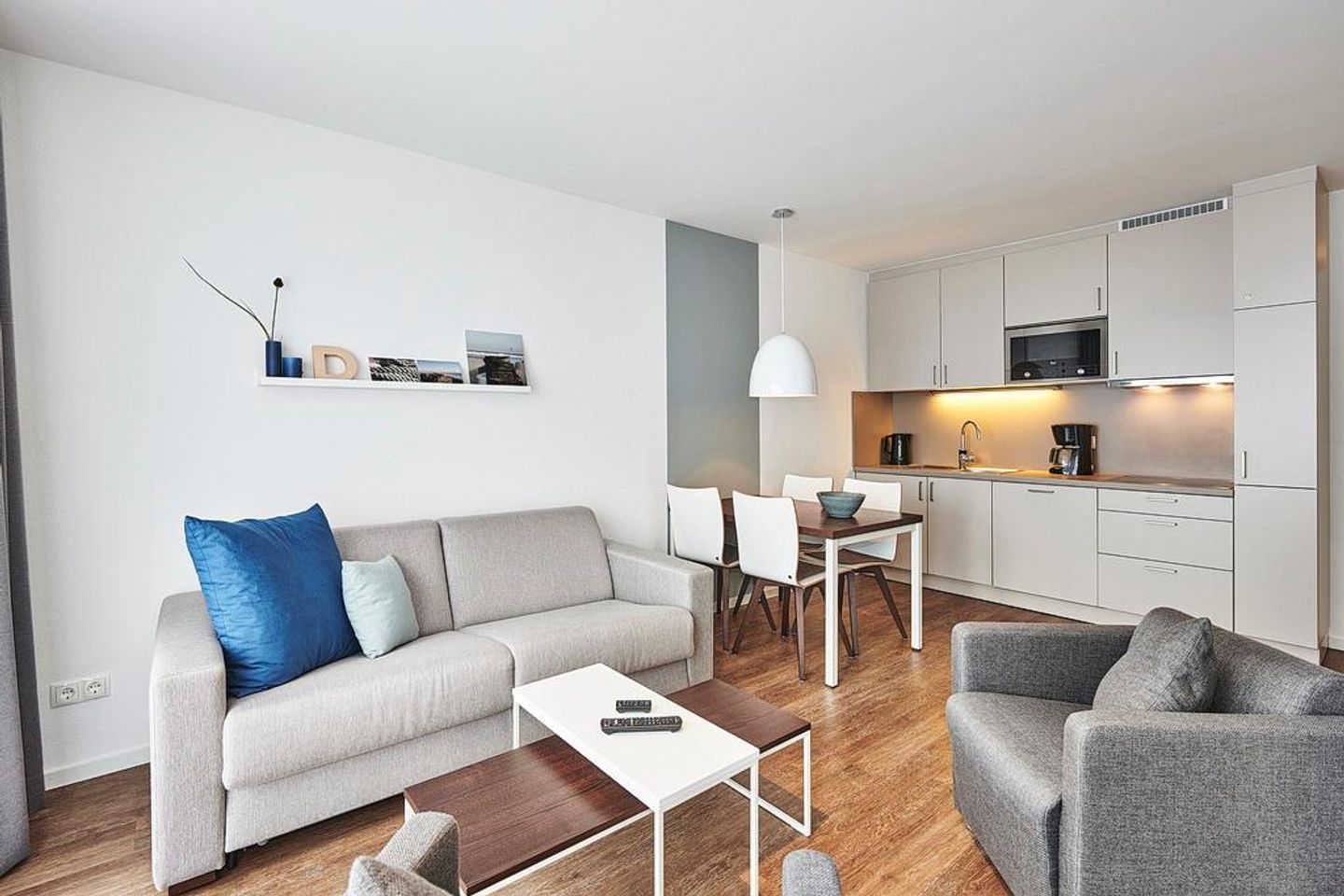 Deichhäuser Anna Küste Deichhäuser Anna Küste 4-34 Bensersiel - Wohnbereich mit Küchenzeile, Esstisch und Sitzgelegenheit