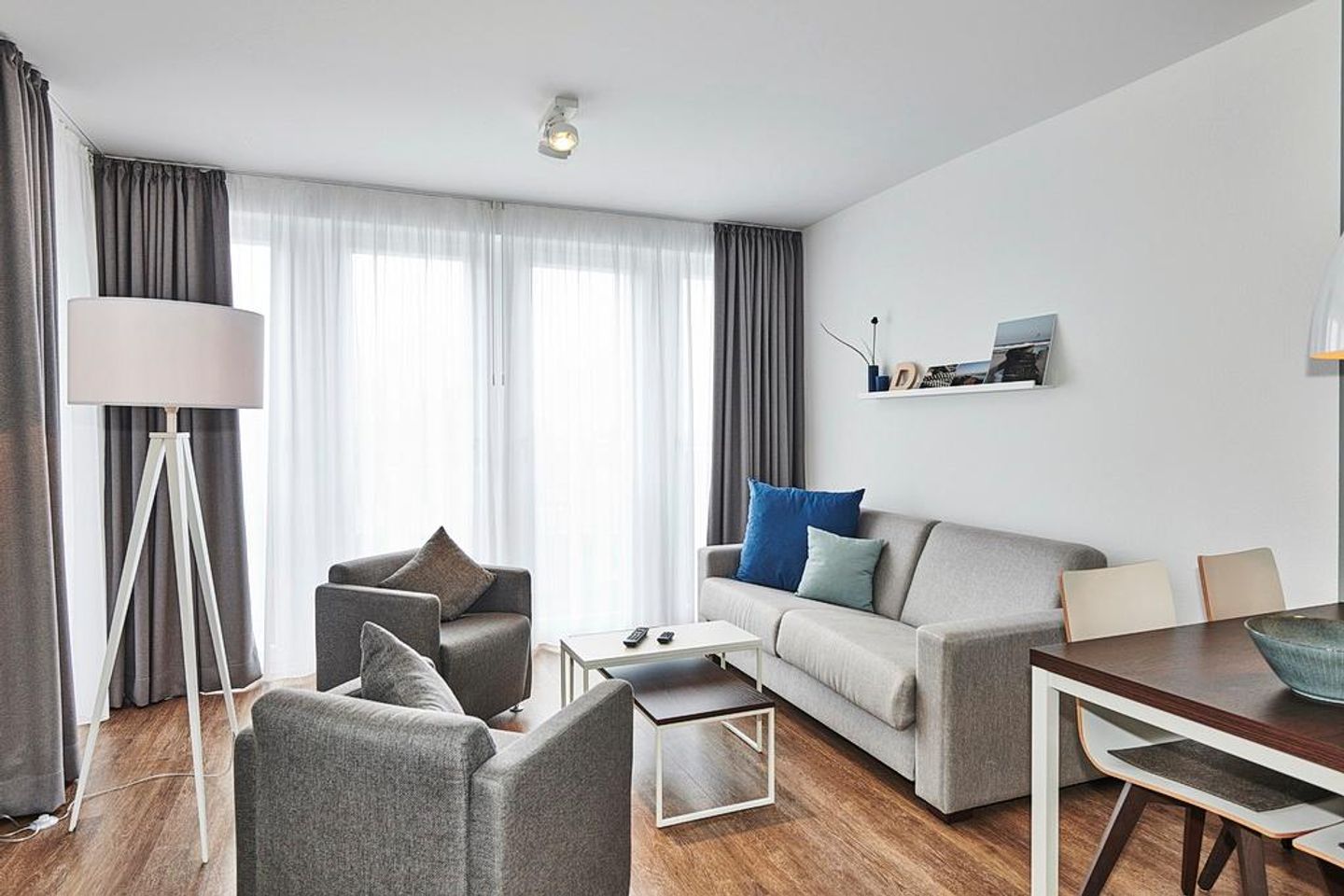 Deichhäuser Anna Küste Deichhäuser Anna Küste 4-34 Bensersiel - Wohn-Essbereich mit Couch, Sessel, Esstisch und Zugang zum Balkon