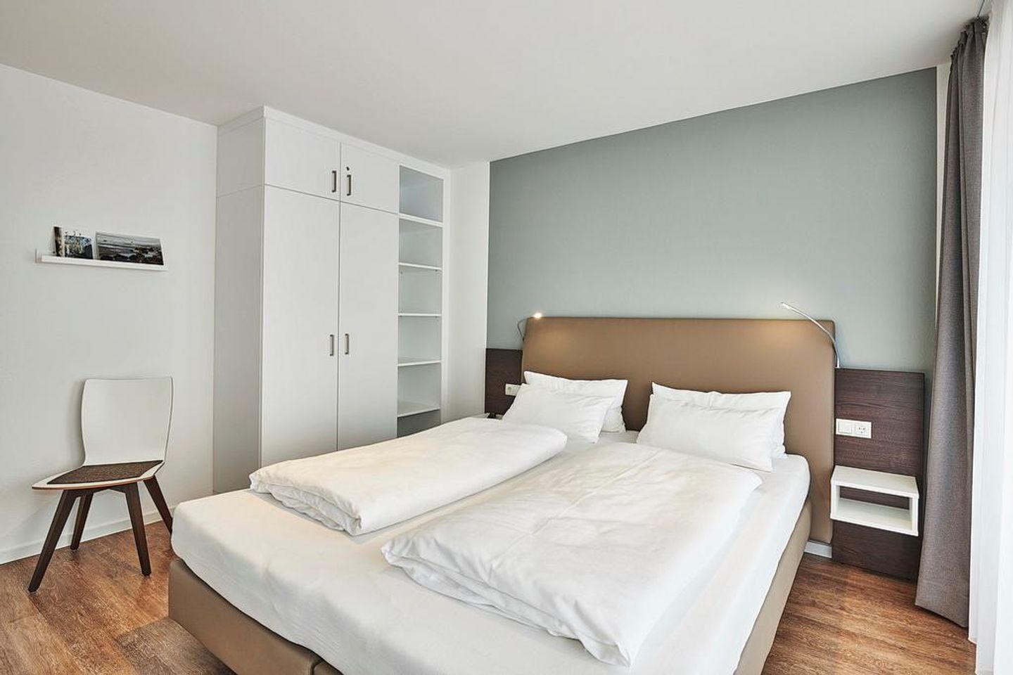 Deichhäuser Anna Küste Deichhäuser Anna Küste 4-34 Bensersiel - Schlafzimmer mit Doppelbett, Kleiderschrank und Stuhl