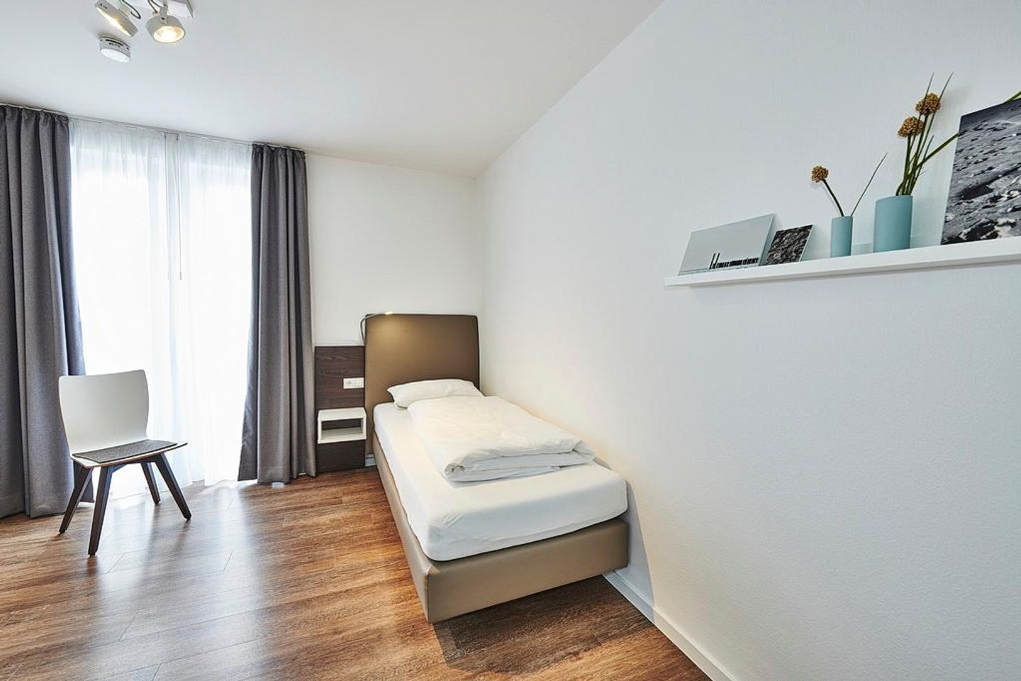 Deichhäuser Anna Küste Deichhäuser Anna Küste 4-34 Bensersiel - Schlafzimmer mit zwei Einzelbetten und Stuhl