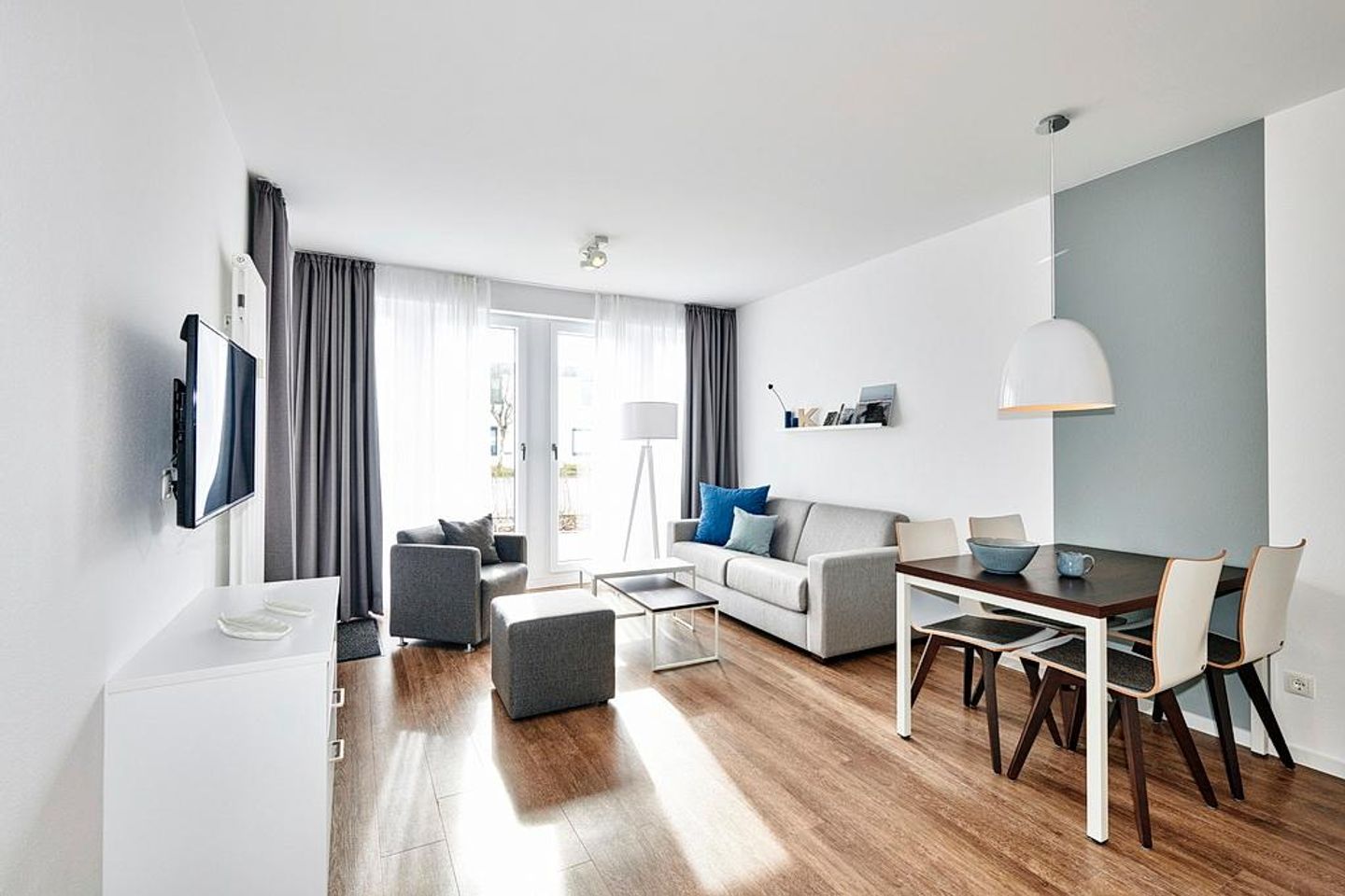 Deichhäuser Anna Küste Deichhäuser Anna Küste 4-14 Bensersiel - Wohn-Essbereich mit Couch, Sesseln und Zugang zur Terrasse