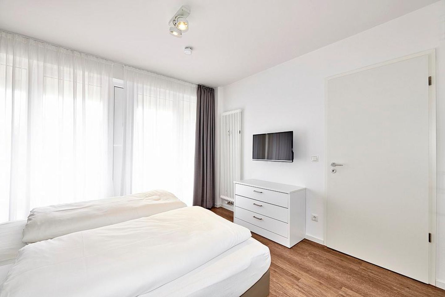 Deichhäuser Anna Küste Deichhäuser Anna Küste 4-14 Bensersiel - Schlafzimmer mit Doppelbett, Flatscreen-TV und Zugang zur Terrasse