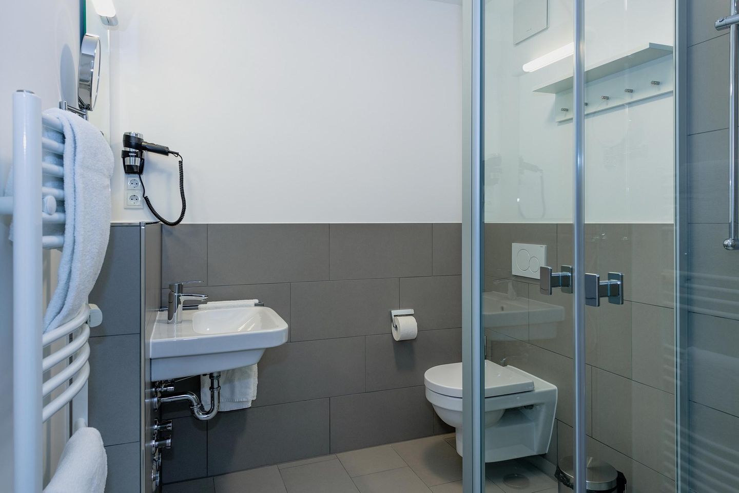 Deichhäuser Anna Küste Deichhäuser Anna Küste 6-13 Bensersiel - Badezimmer mit Dusche, Waschtisch, WC und Spiegel