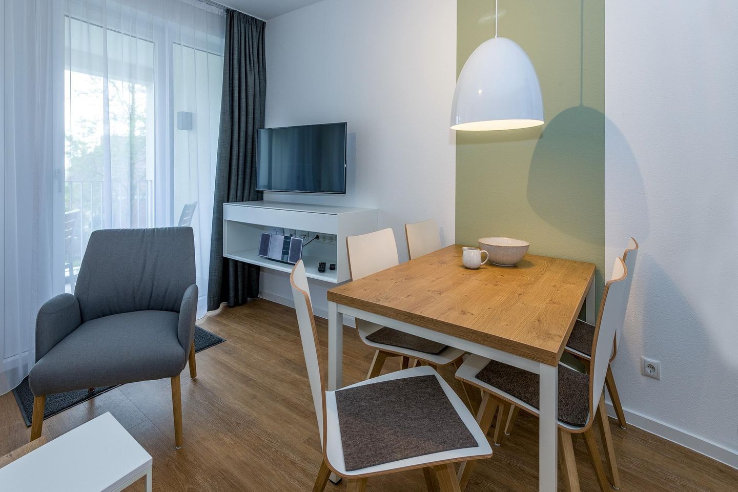 Deichhäuser Anna Küste Deichhäuser Anna Küste 6-21 Bensersiel - Wohn-Essbereich mit Esstisch, Sitzgelegenheit und Flatscreen TV