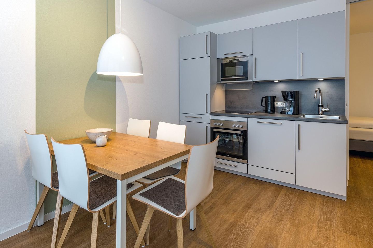 Deichhäuser Anna Küste Deichhäuser Anna Küste 6-21 Bensersiel - Wohn-Essbereich mit Esstisch, Sitzgelegenheit und Küchenzeile