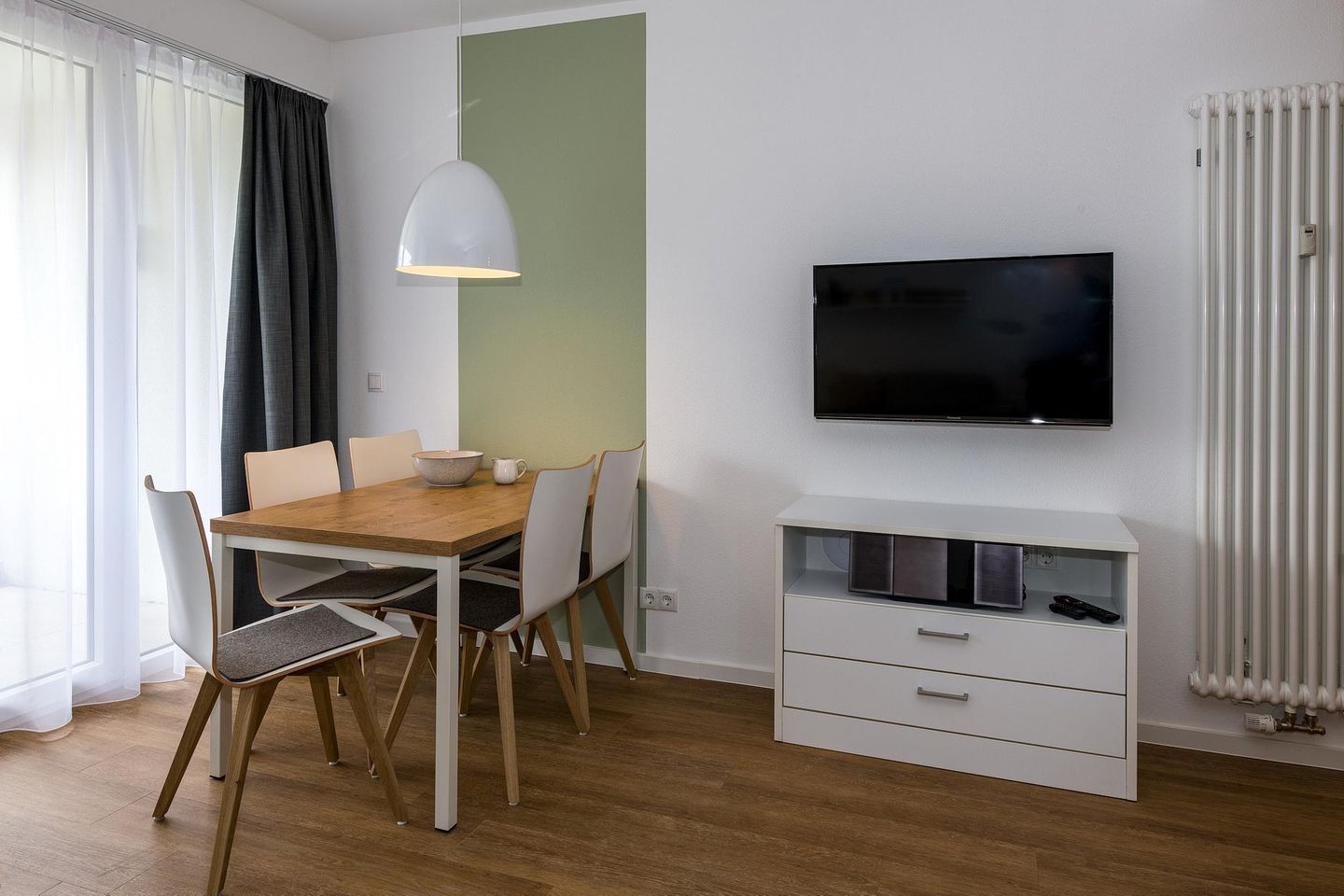 Deichhäuser Anna Küste Deichhäuser Anna Küste 6-23 Bensersiel - Wohn-Essbereich mit Couch und Flatscreen TV