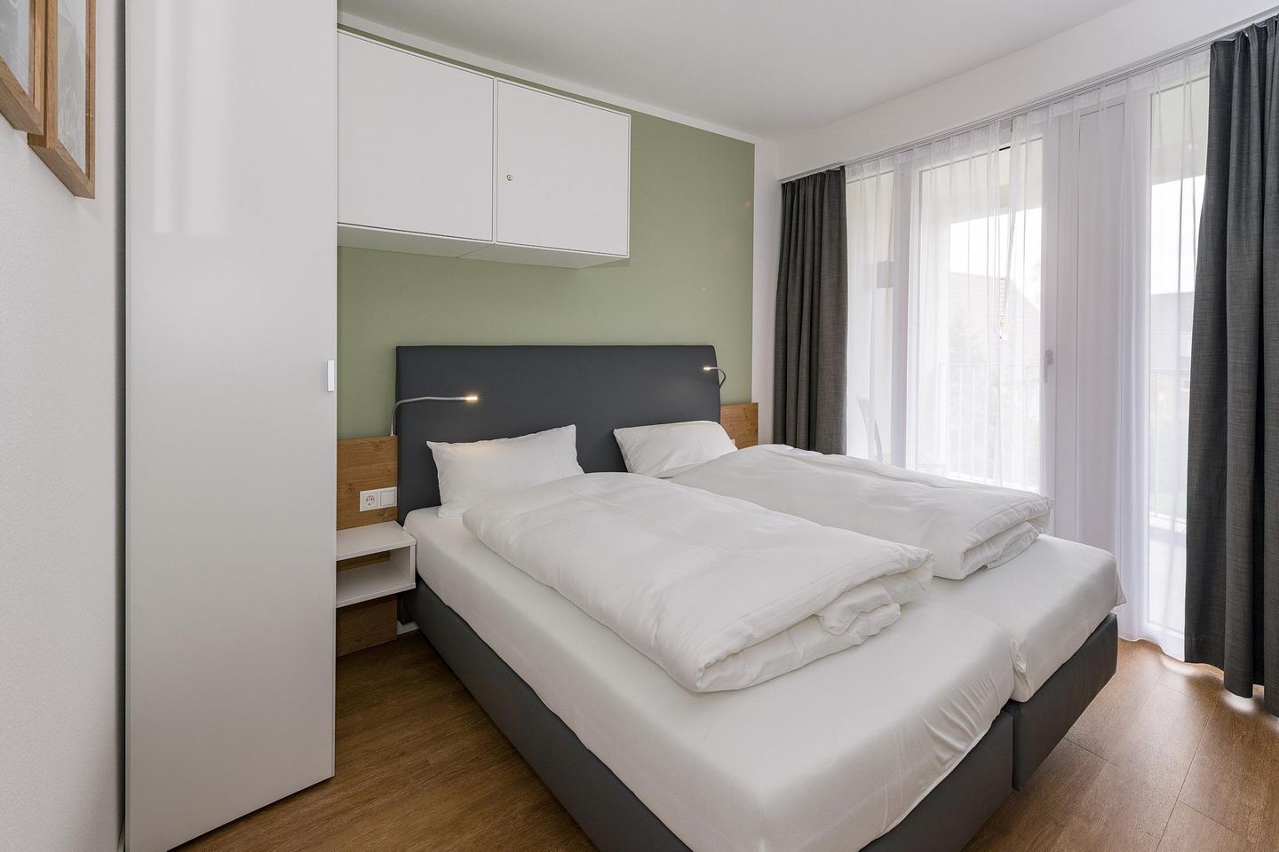 Deichhäuser Anna Küste Deichhäuser Anna Küste 6-23 Bensersiel - Schlafzimmer mit Doppelbett, Kleiderschrank und Zugang zum Balkon