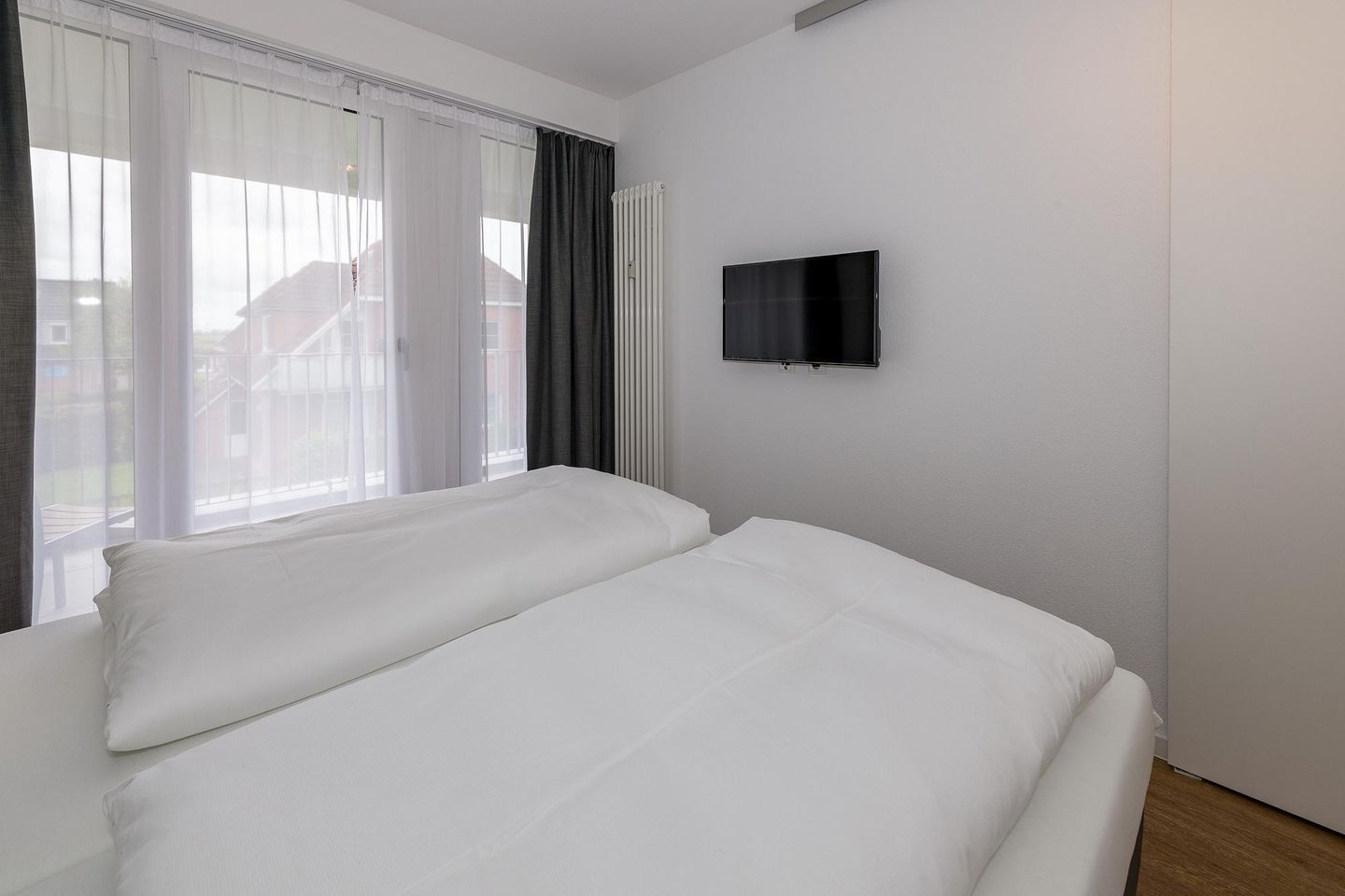 Deichhäuser Anna Küste Deichhäuser Anna Küste 6-23 Bensersiel - Schlafzimmer mit Doppelbett und Zugang zum Balkon