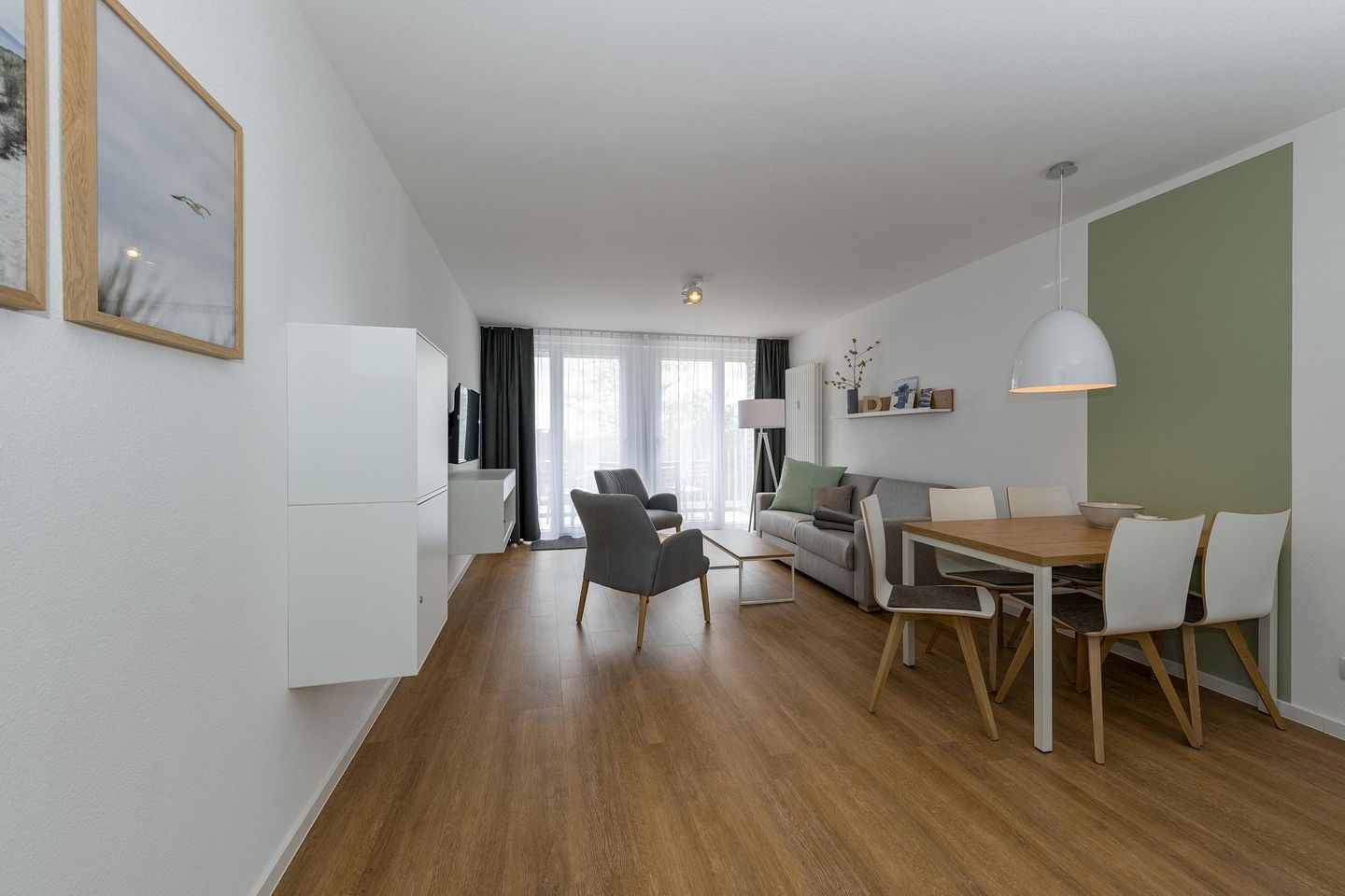 Deichhäuser Anna Küste Deichhäuser Anna Küste 6-30 Bensersiel - Wohn-Essbereich mit Esstisch, Sitzgelegenheit und Zugang zum Balkon