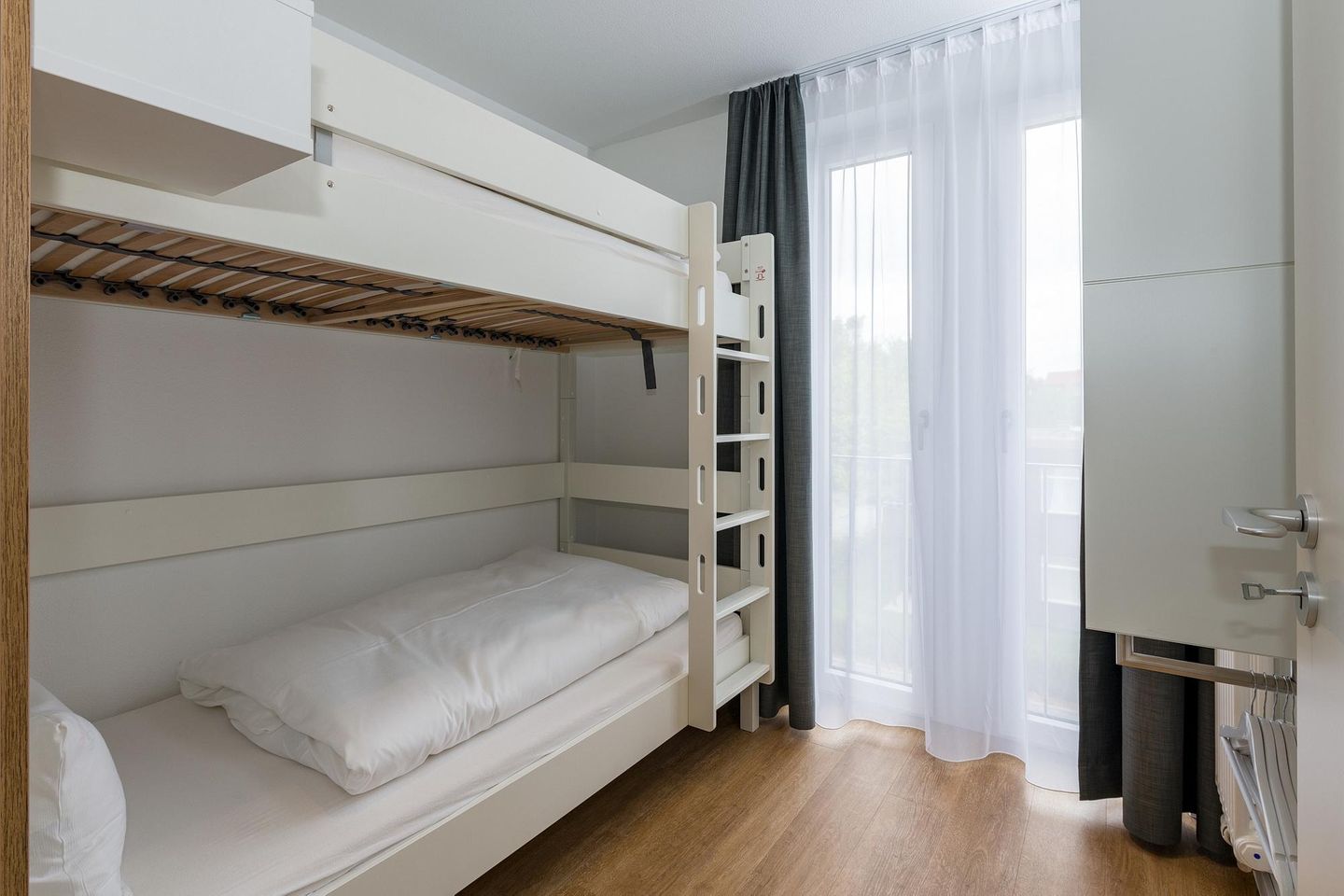 Deichhäuser Anna Küste Deichhäuser Anna Küste 6-30 Bensersiel - Schlafzimmer mit Etagenbett und Kleiderschrank