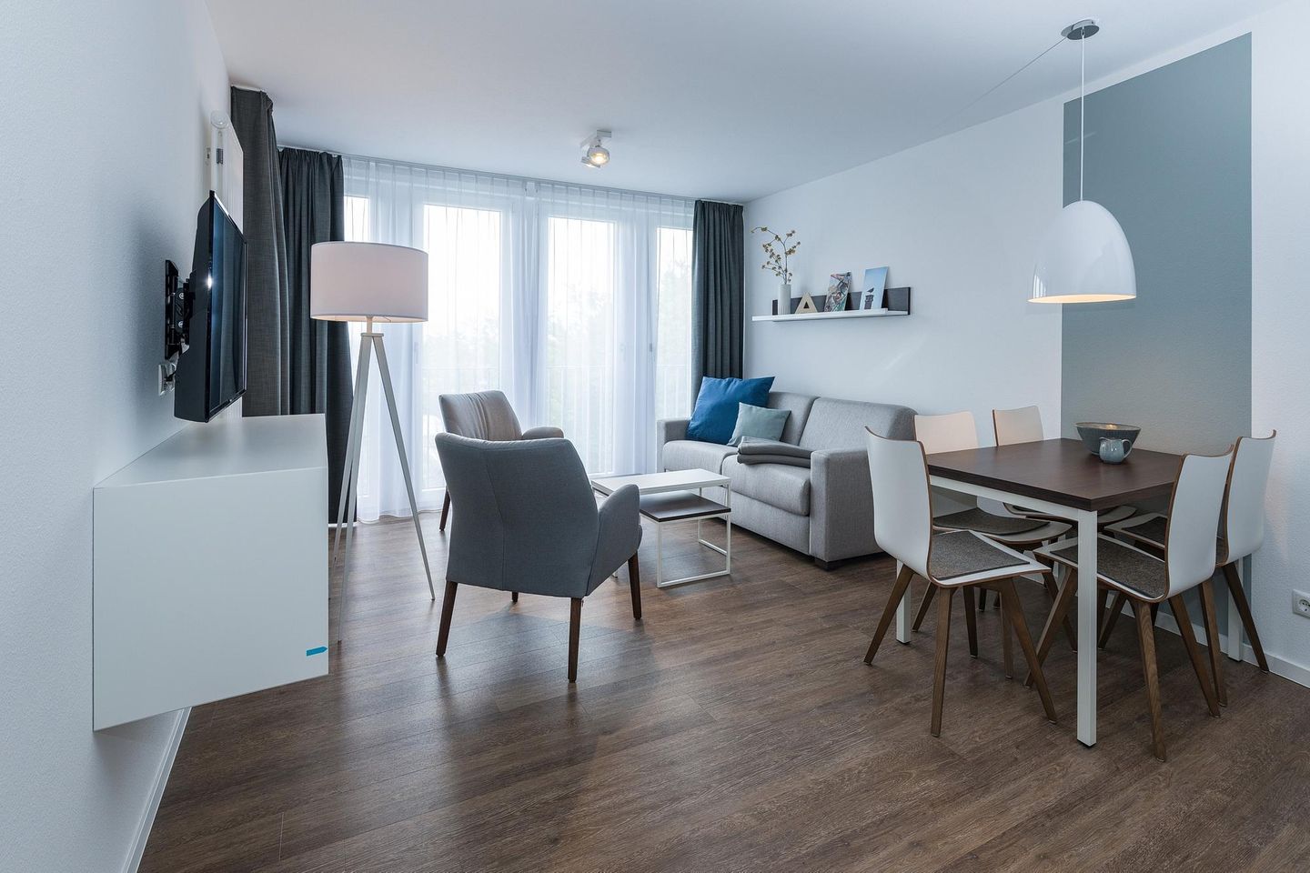 Deichhäuser Anna Küste Deichhäuser Anna Küste 6-34 Bensersiel - Wohn-Essbereich mit Couch, Esstisch, Sitzgelegenheit und Flatscreen TV