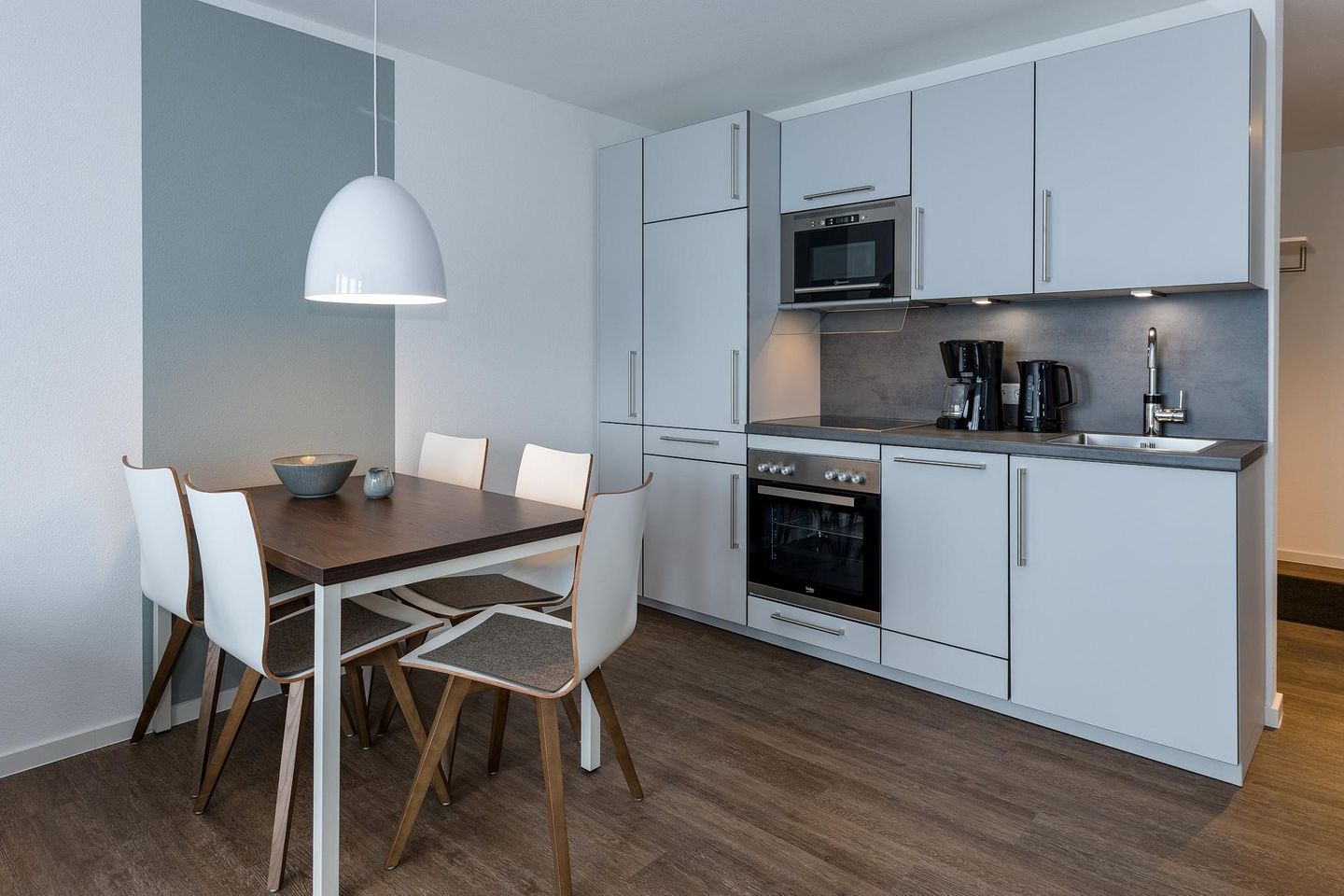 Deichhäuser Anna Küste Deichhäuser Anna Küste 6-34 Bensersiel - Wohn-Essbereich mit Esstisch, Sitzgelegenheit und Küchenzeile