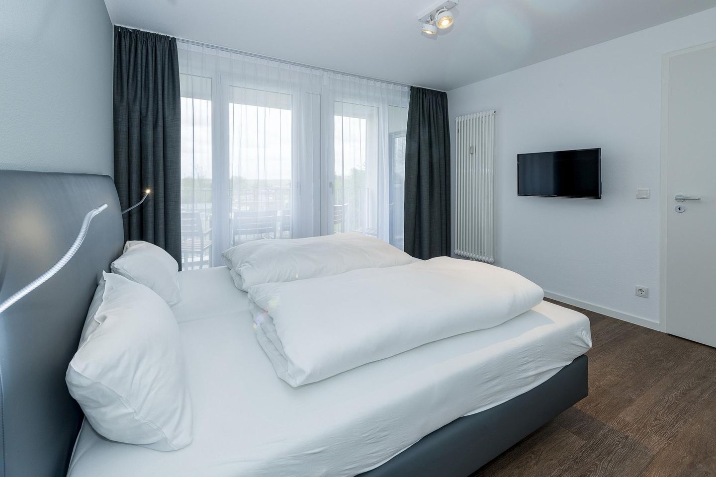 Deichhäuser Anna Küste Deichhäuser Anna Küste 6-34 Bensersiel - Schlafzimmer mit Doppelbett, Flatscreen-TV und Zugang zum Balkon