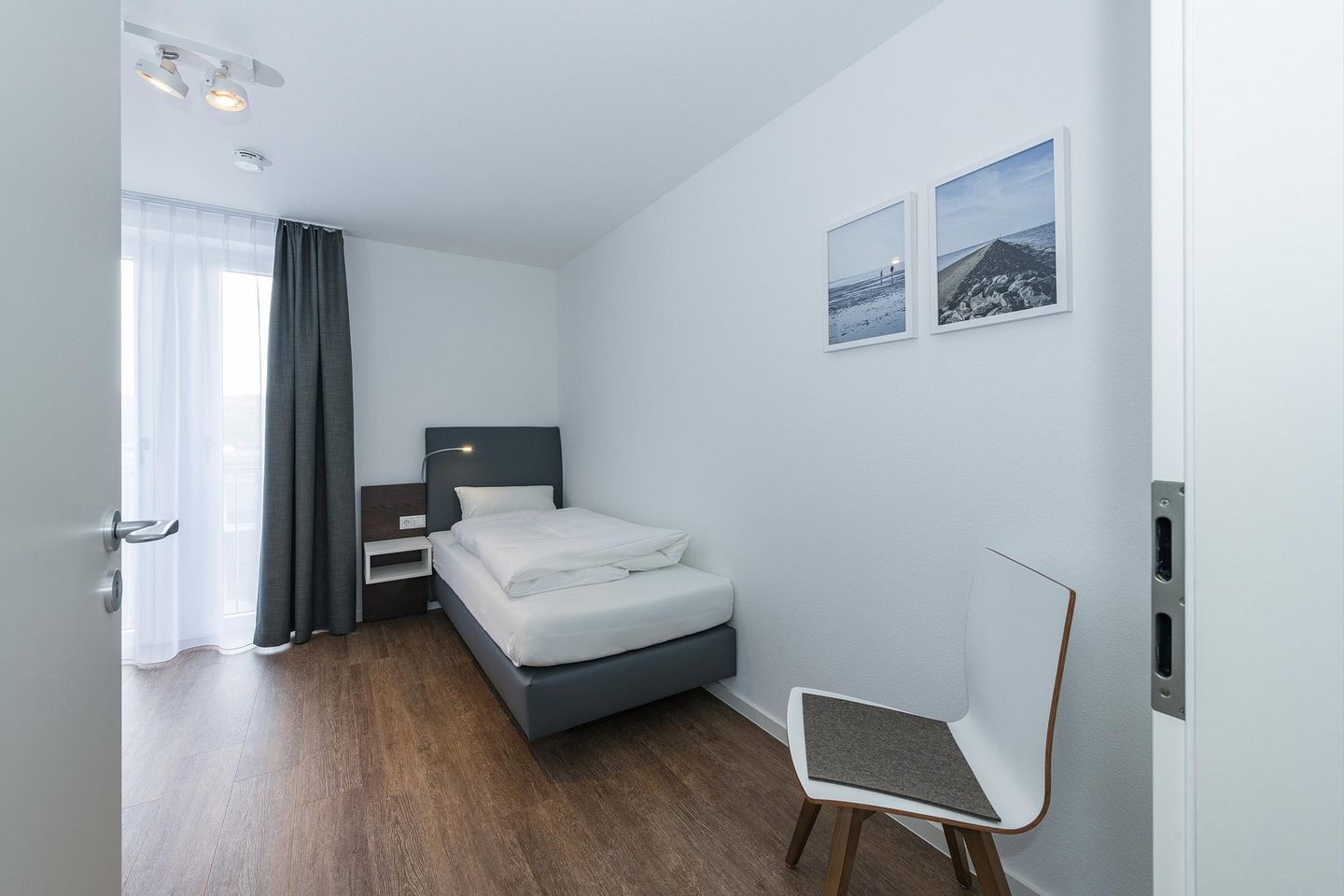 Deichhäuser Anna Küste Deichhäuser Anna Küste 6-34 Bensersiel - Schlafzimmer mit zwei Einzelbetten und Stuhl