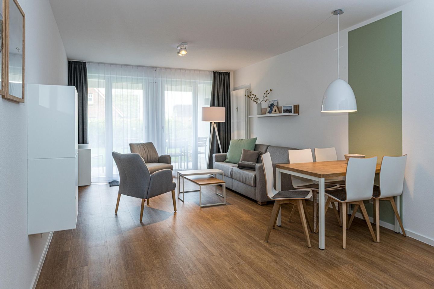 Deichhäuser Anna Küste Deichhäuser Anna Küste 7-10 Bensersiel - Wohn-Essbereich mit Couch, Esstisch, Sitzgelegenheit und Flatscreen TV