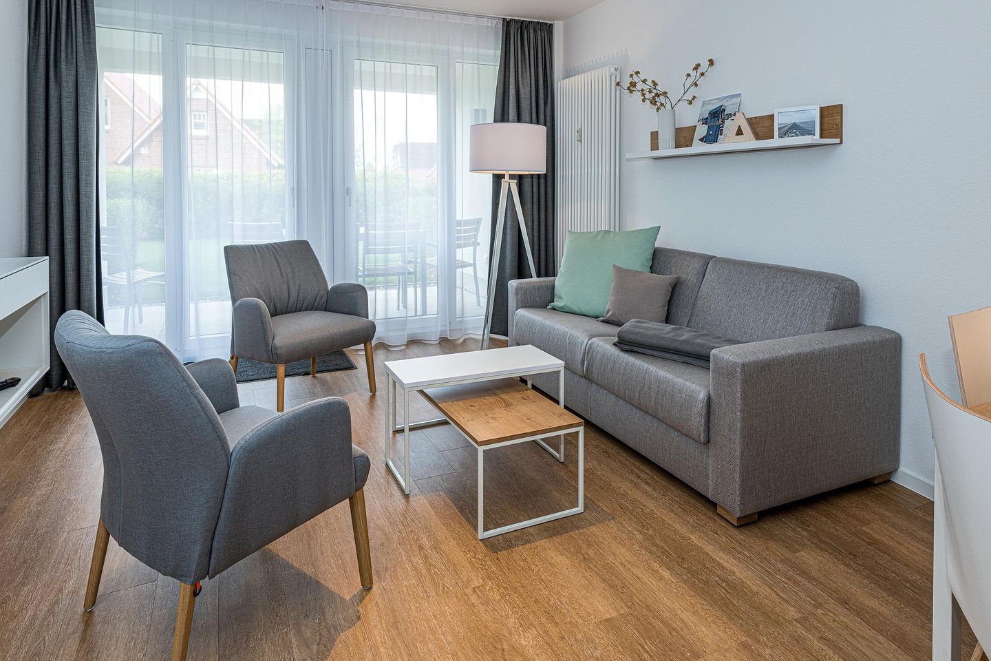 Deichhäuser Anna Küste Deichhäuser Anna Küste 7-10 Bensersiel - Wohn-Essbereich mit Couch und Zugang zur Terrasse