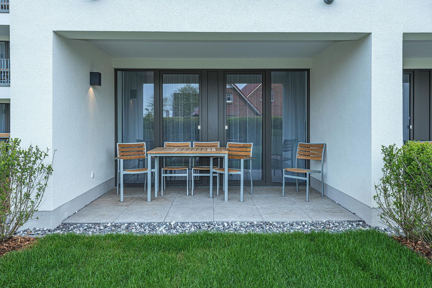 Deichhäuser Anna Küste Deichhäuser Anna Küste 7-10 Bensersiel - Überdachte Terrasse mit Sitzgelegenheit und Grünfläche