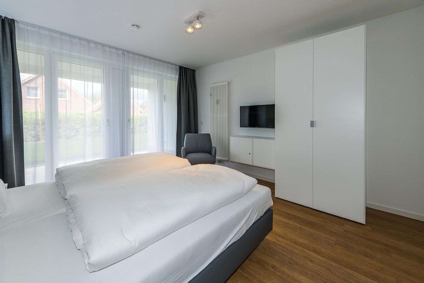 Deichhäuser Anna Küste Deichhäuser Anna Küste 7-11 Bensersiel - Schlafzimmer mit Doppelbett, Kleiderschrank und Flatscreen TV