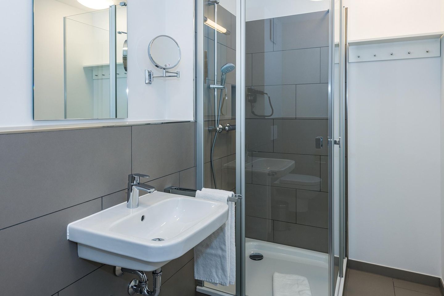 Deichhäuser Anna Küste Deichhäuser Anna Küste 7-11 Bensersiel - Badezimmer mit Dusche, Waschbecken und Spiegel