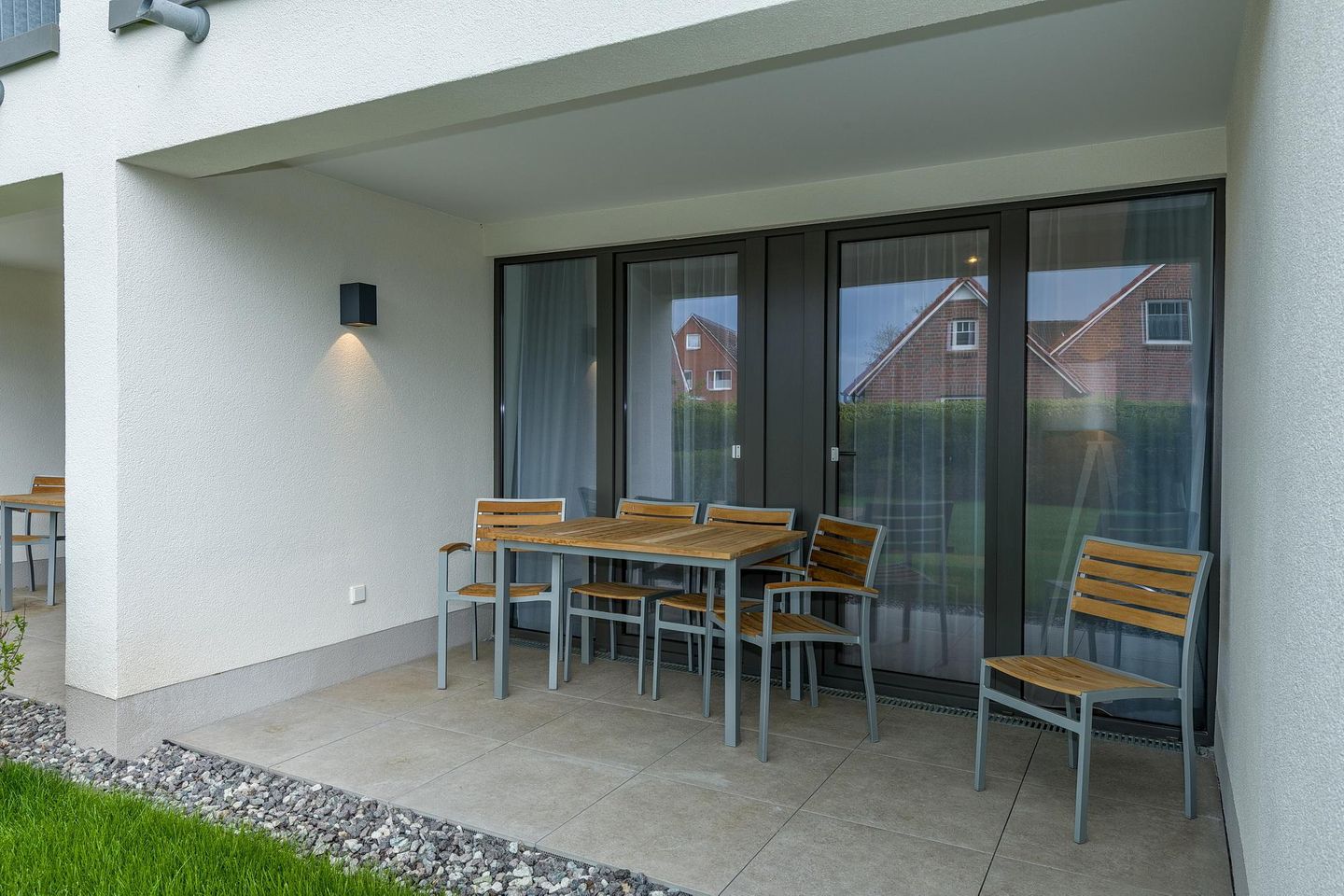 Deichhäuser Anna Küste Deichhäuser Anna Küste 7-11 Bensersiel - Überdachte Terrasse mit Sitzgelegenheit