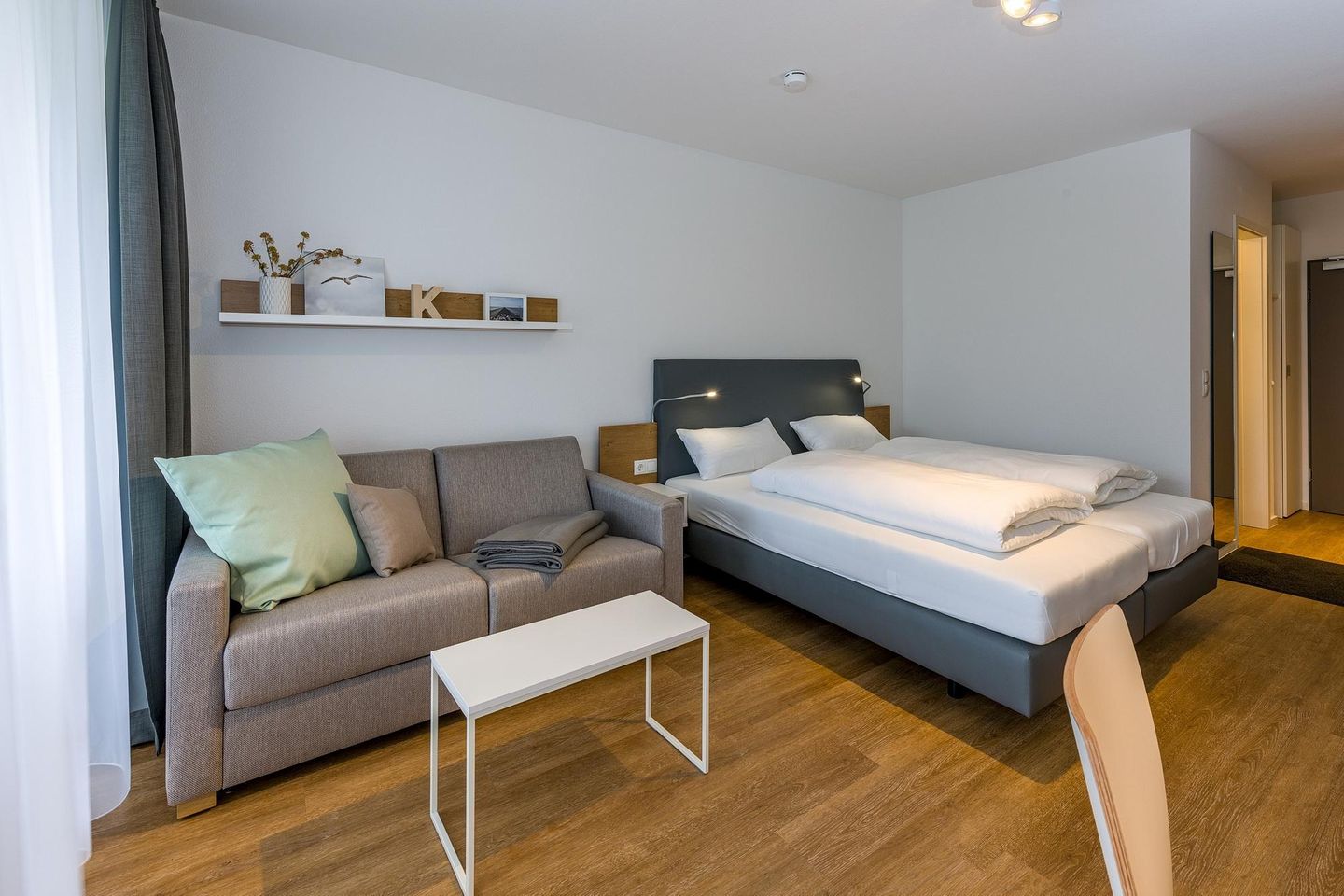 Deichhäuser Anna Küste Deichhäuser Anna Küste 7-12 Bensersiel - Wohn-Ess-Schlafbereich mit Doppelbett und Sofa