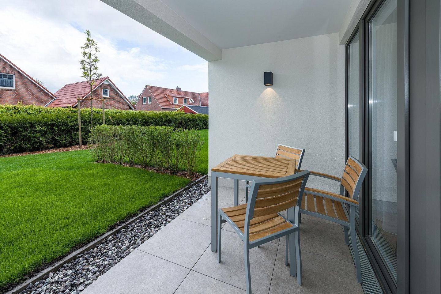 Deichhäuser Anna Küste Deichhäuser Anna Küste 7-12 Bensersiel - Überdachte Terrasse mit Sitzgelegenheit und Grünfläche