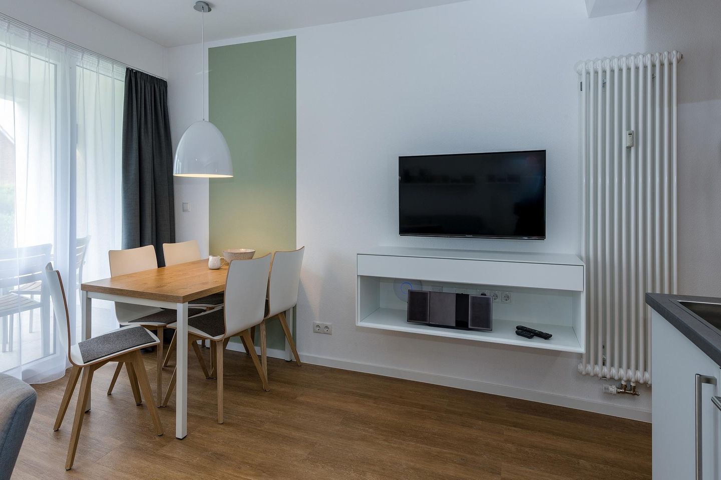 Deichhäuser Anna Küste Deichhäuser Anna Küste 7-13 Bensersiel - Wohn-Essbereich mit Esstisch, Sitzgelegenheit und Flatscreen TV