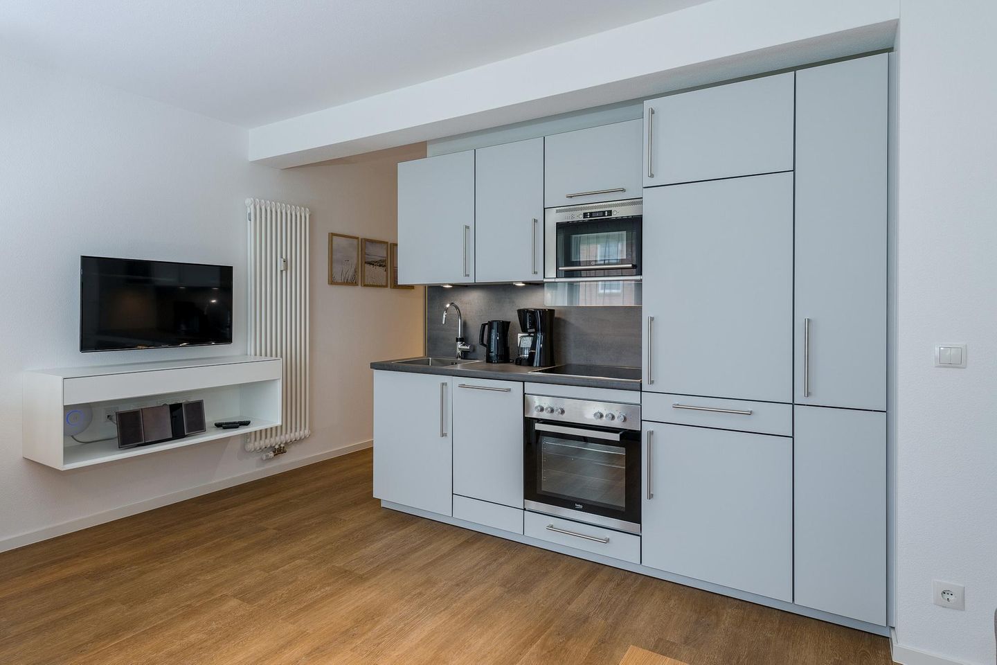 Deichhäuser Anna Küste Deichhäuser Anna Küste 7-13 Bensersiel - Wohn-Essbereich mit Küchenzeile und Flatscreen TV