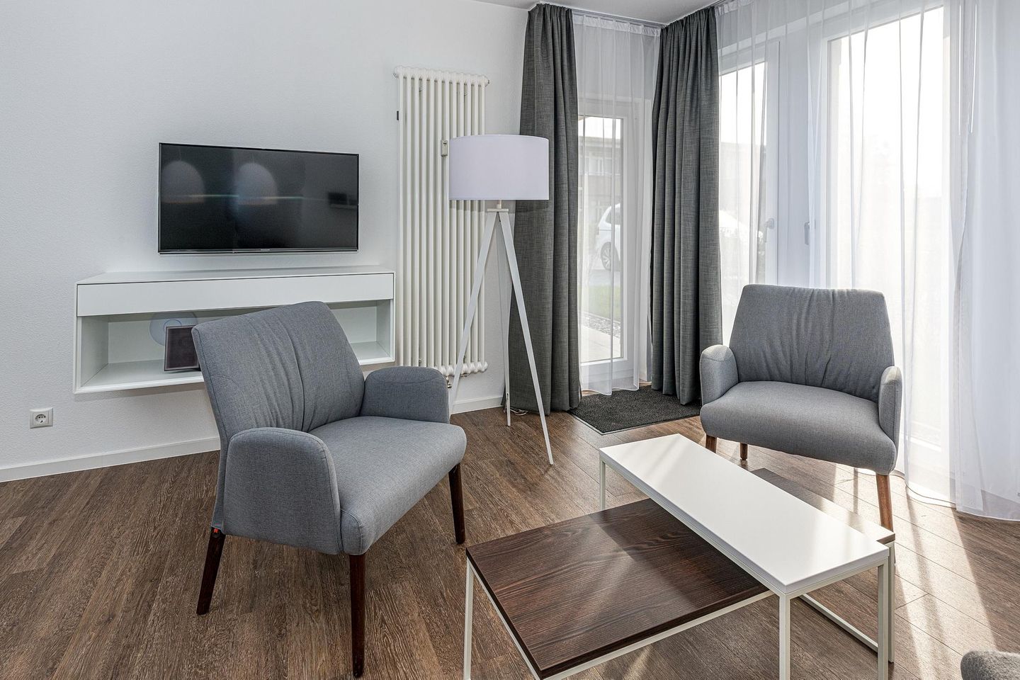 Deichhäuser Anna Küste Deichhäuser Anna Küste 7-14 Bensersiel - Wohn-Essbereich mit Flatscreen TV, Sitzgelegenheit und Zugang zur Terrasse