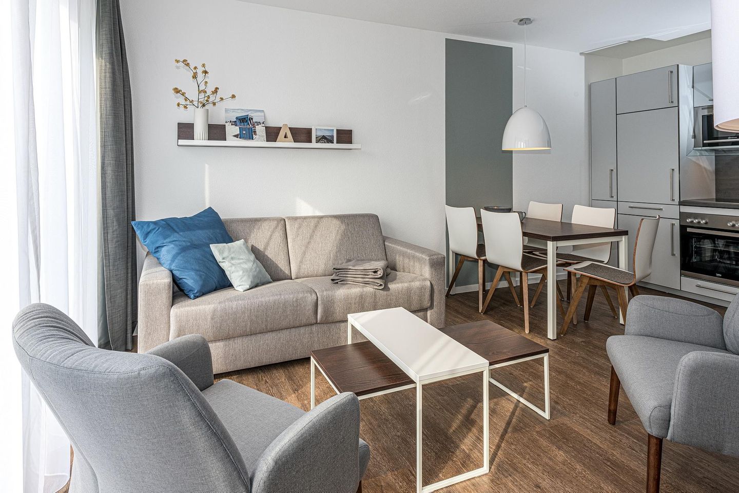 Deichhäuser Anna Küste Deichhäuser Anna Küste 7-14 Bensersiel - Wohn-Essbereich mit Couch, Sessel und Esstisch