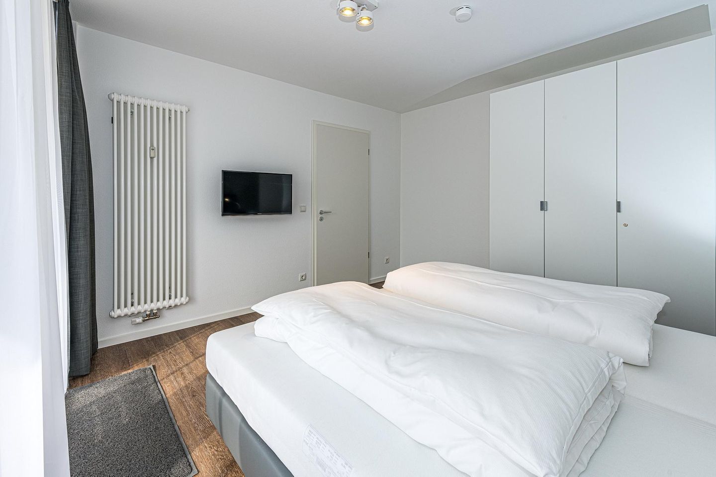 Deichhäuser Anna Küste Deichhäuser Anna Küste 7-14 Bensersiel - Schlafzimmer mit Doppelbett, Kleiderschrank und Flatscreen TV