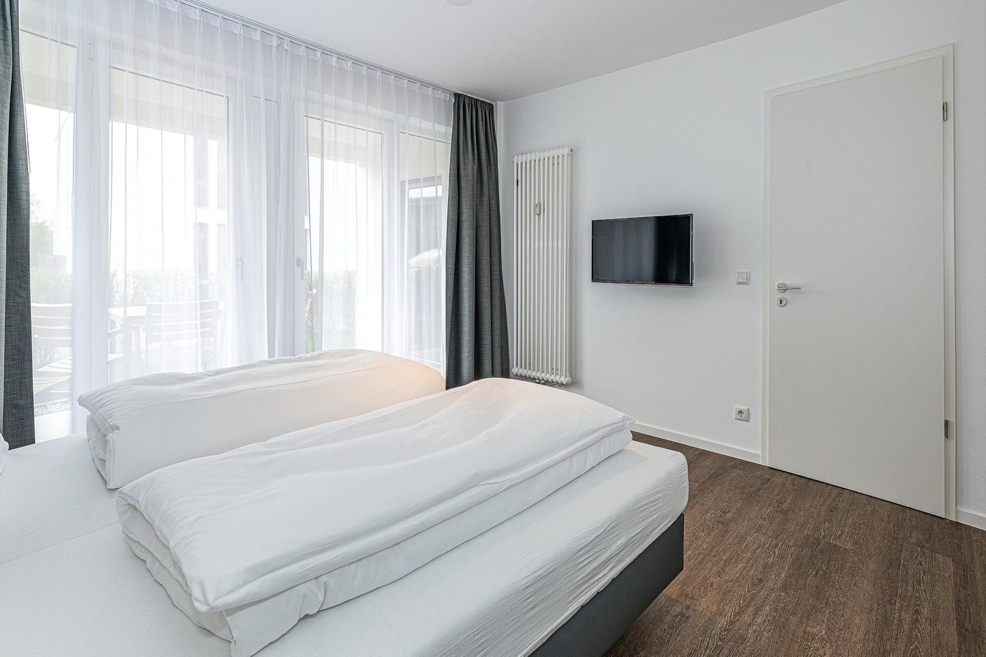 Deichhäuser Anna Küste Deichhäuser Anna Küste 7-14 Bensersiel - Schlafzimmer mit Doppelbett, Flatscreen-TV und Zugang zur Terrasse