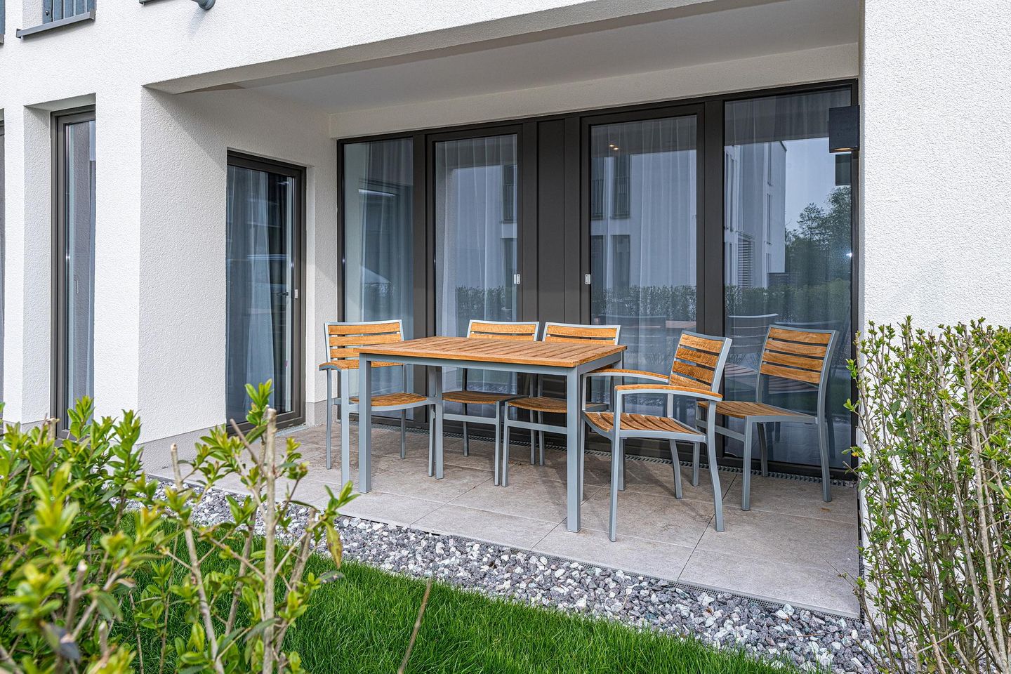 Deichhäuser Anna Küste Deichhäuser Anna Küste 7-14 Bensersiel - Überdachte Terrasse mit Sitzgelegenheit und Grünfläche