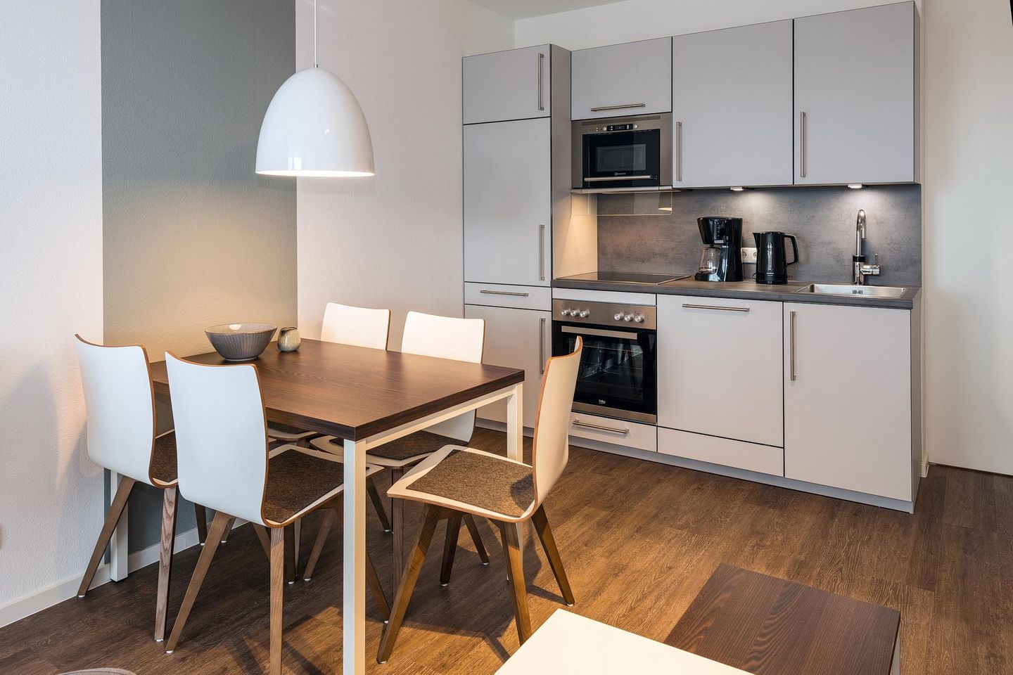 Deichhäuser Anna Küste Deichhäuser Anna Küste 7-21 Bensersiel - Wohn-Essbereich mit Esstisch, Sitzgelegenheit und Küchenzeile