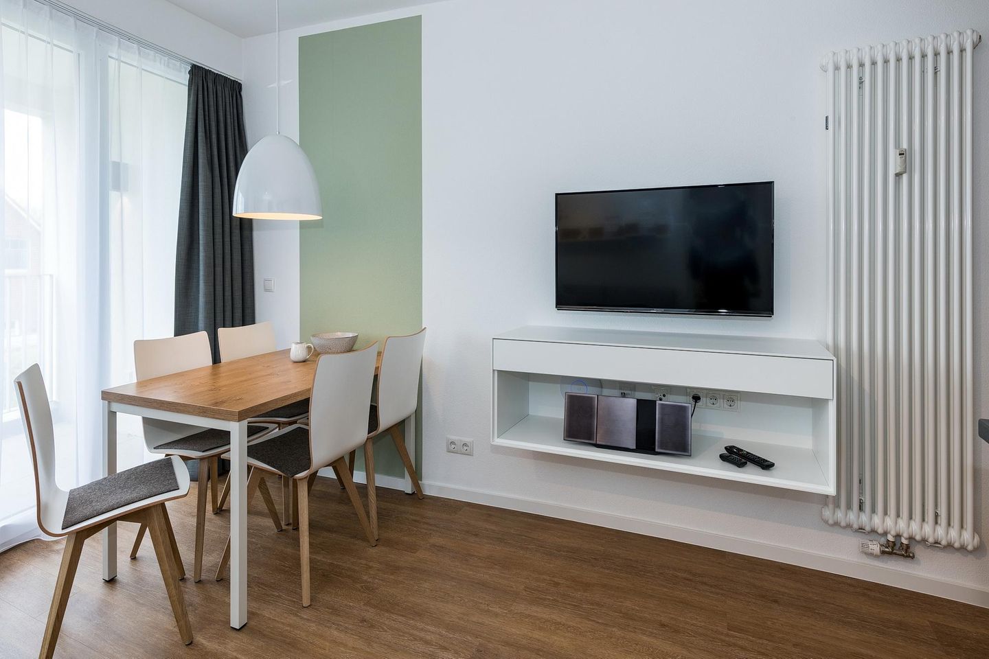 Deichhäuser Anna Küste Deichhäuser Anna Küste 7-23 Bensersiel - Wohn-Essbereich mit Esstisch, Sitzgelegenheit und Flatscreen TV