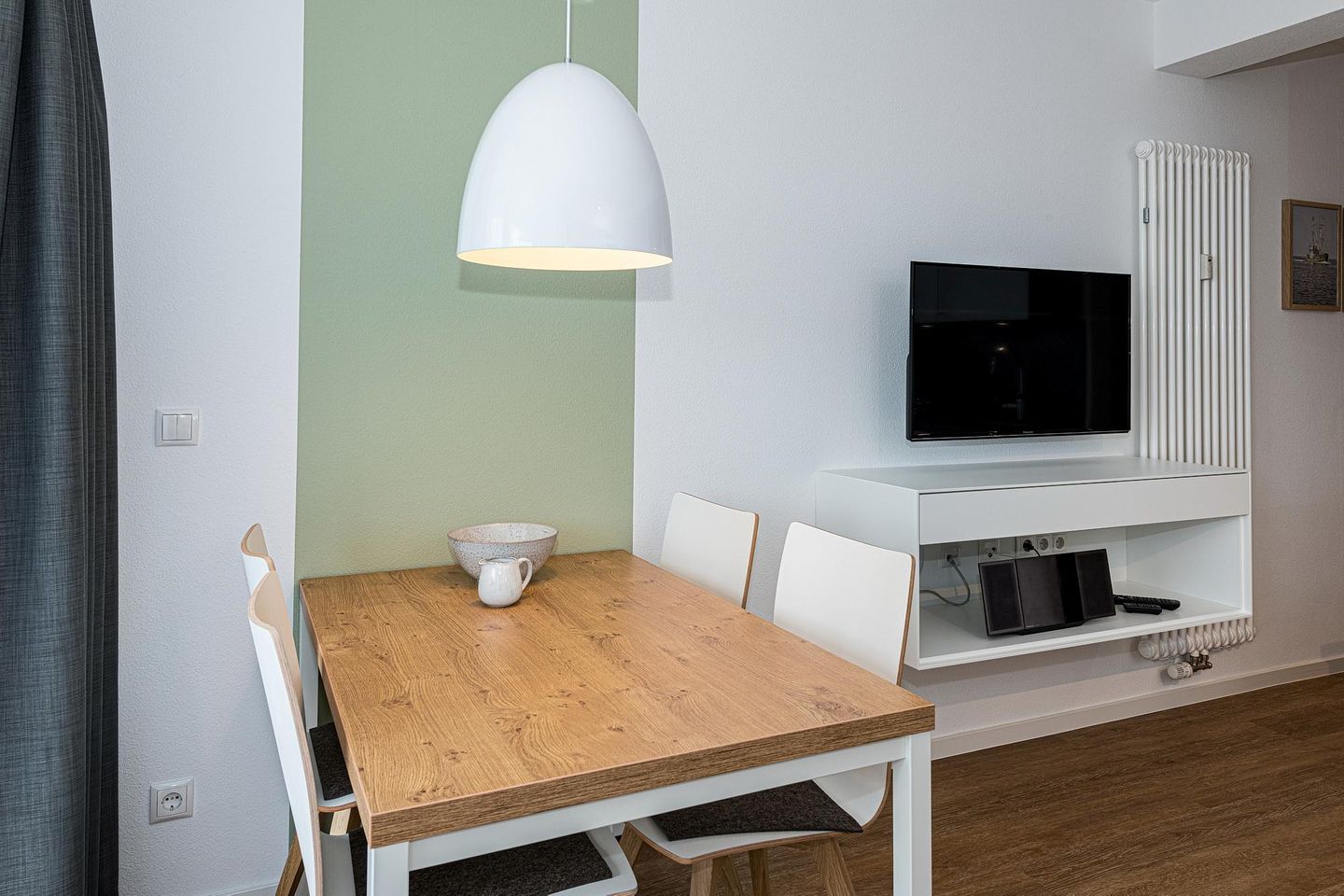 Deichhäuser Anna Küste Deichhäuser Anna Küste 7-23 Bensersiel - Wohn-Essbereich mit Esstisch, Sitzgelegenheit und Flatscreen TV