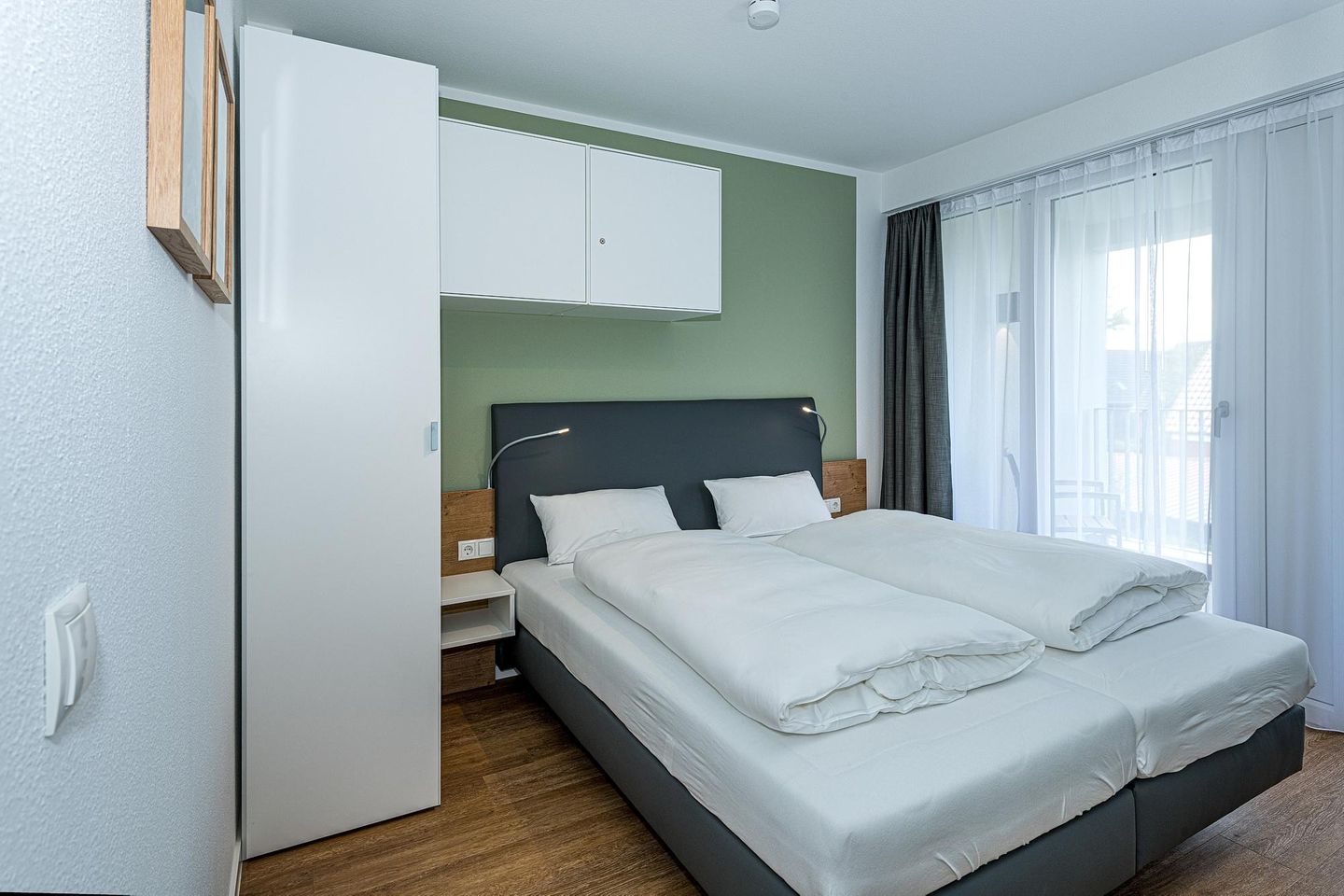 Deichhäuser Anna Küste Deichhäuser Anna Küste 7-23 Bensersiel - Schlafzimmer mit Doppelbett, Kleiderschrank und Zugang zum Balkon