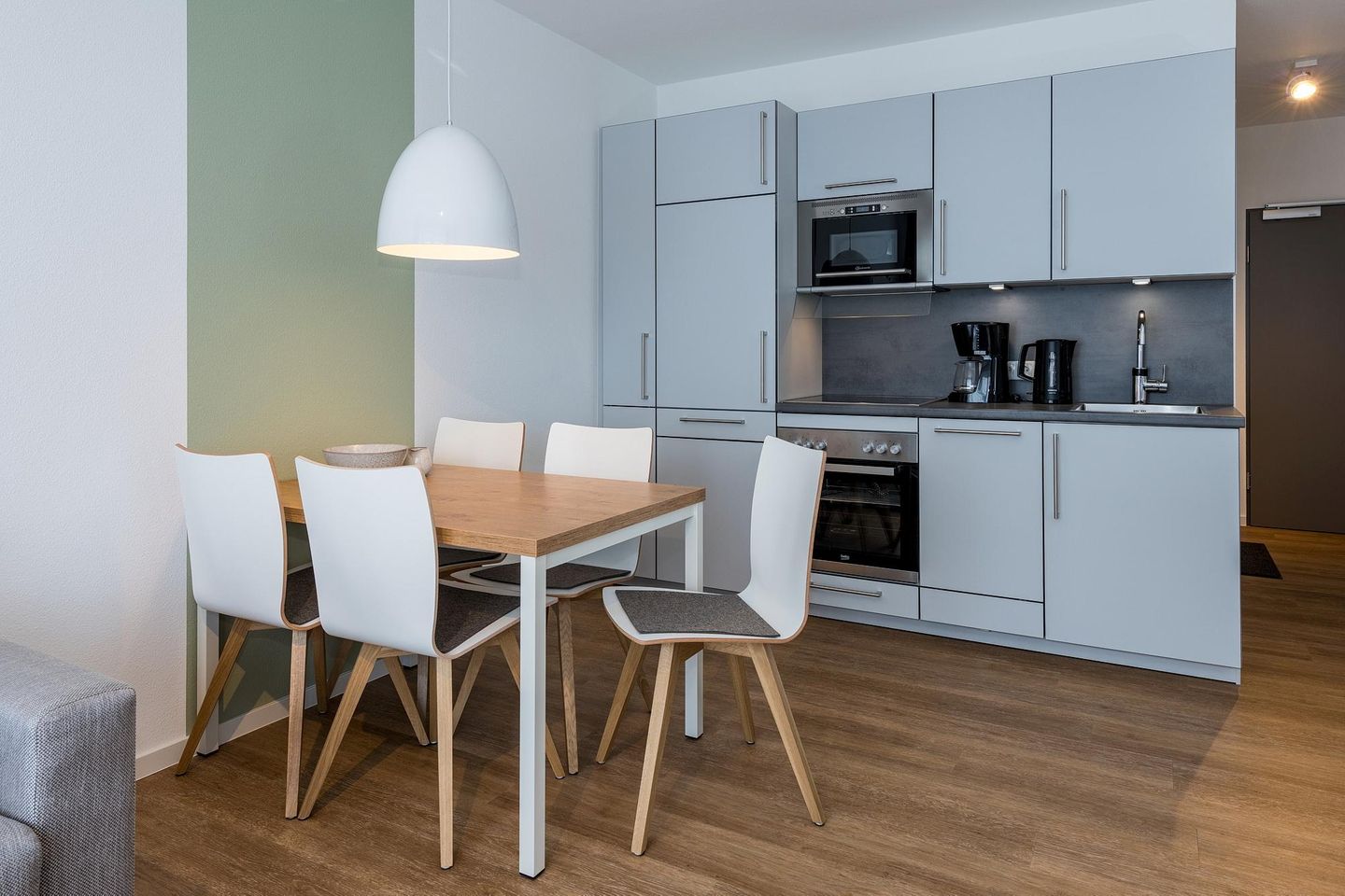 Deichhäuser Anna Küste Deichhäuser Anna Küste 7-24 Bensersiel - Wohn-Essbereich mit Couch und Küchenzeile