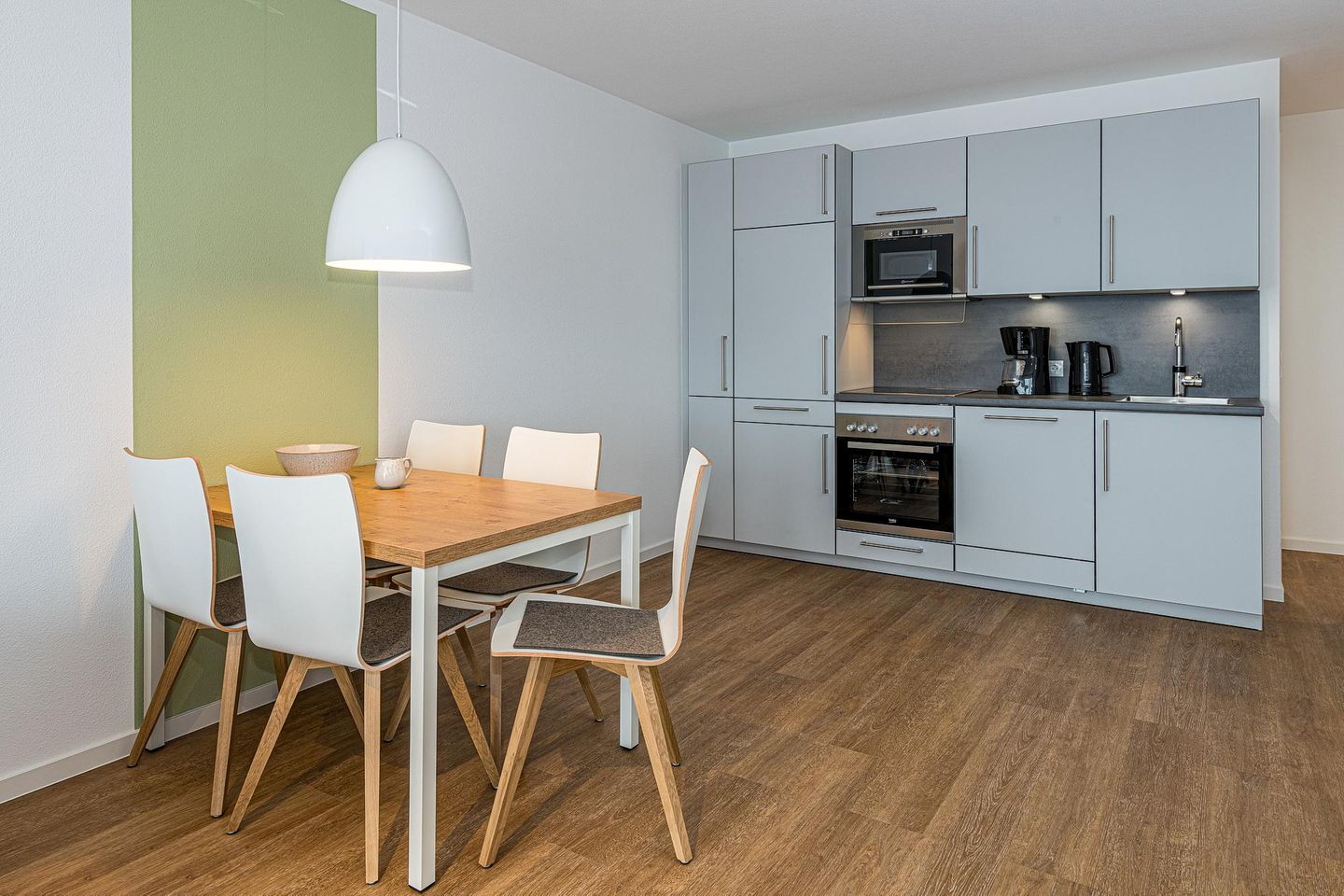 Deichhäuser Anna Küste Deichhäuser Anna Küste 7-30 Bensersiel - Wohn-Essbereich mit Couch und Küchenzeile