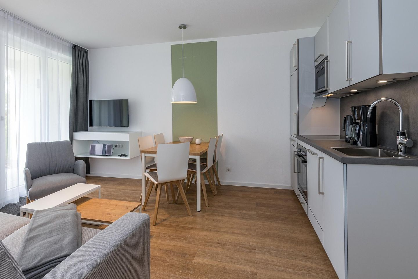 Deichhäuser Anna Küste Deichhäuser Anna Küste 8-11 Bensersiel - Wohn-Essbereich mit Couch und Küchenzeile